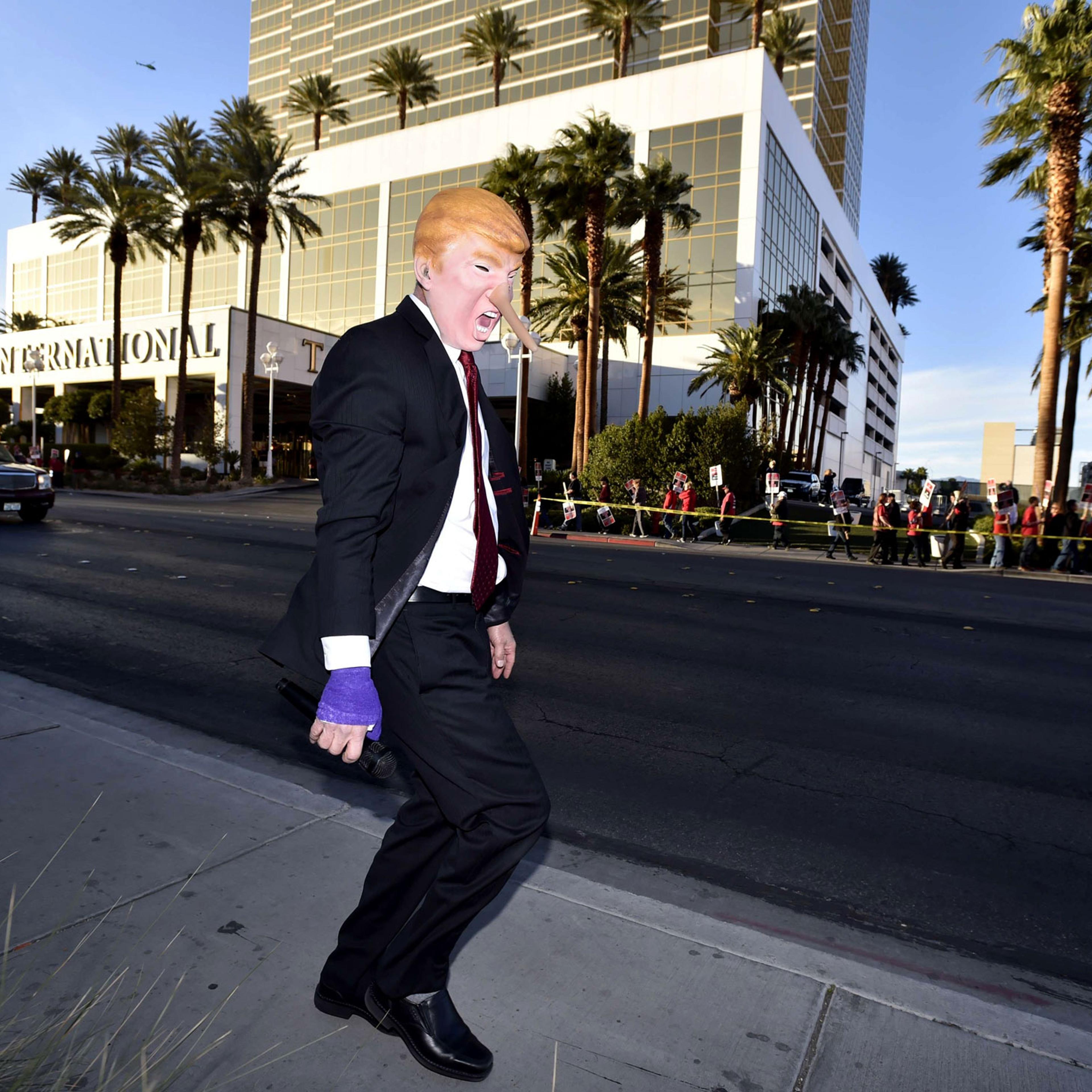 Gil Mobley wears a costume in the likeness of Donald Trump in front of the Trump Hotel in Las Vegas on Feb. 23, 2016.