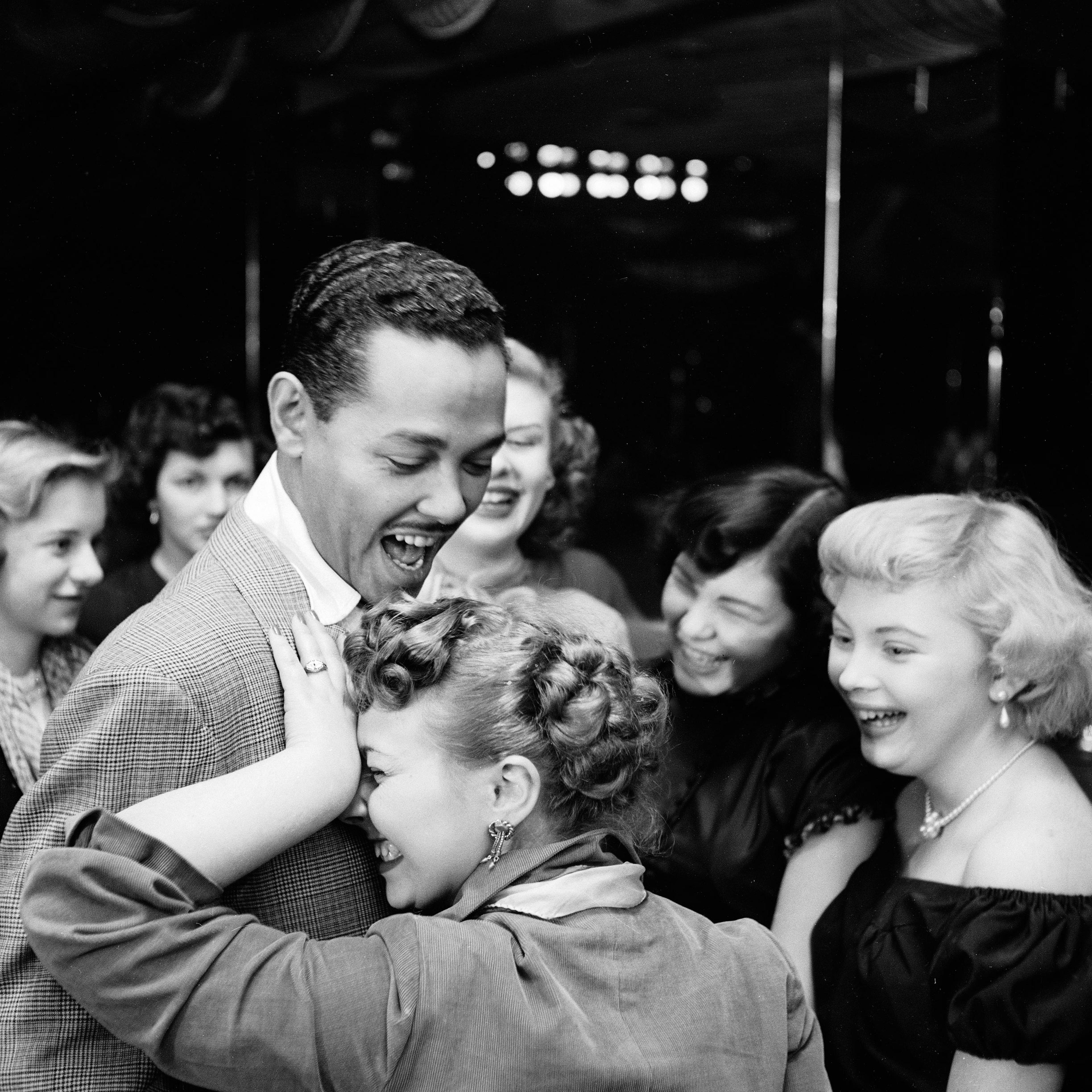 Singer and bandleader Billy Eckstine gets a hug from an adoring fan after a show at the late, great New York City jazz club, Bop City, 1949.