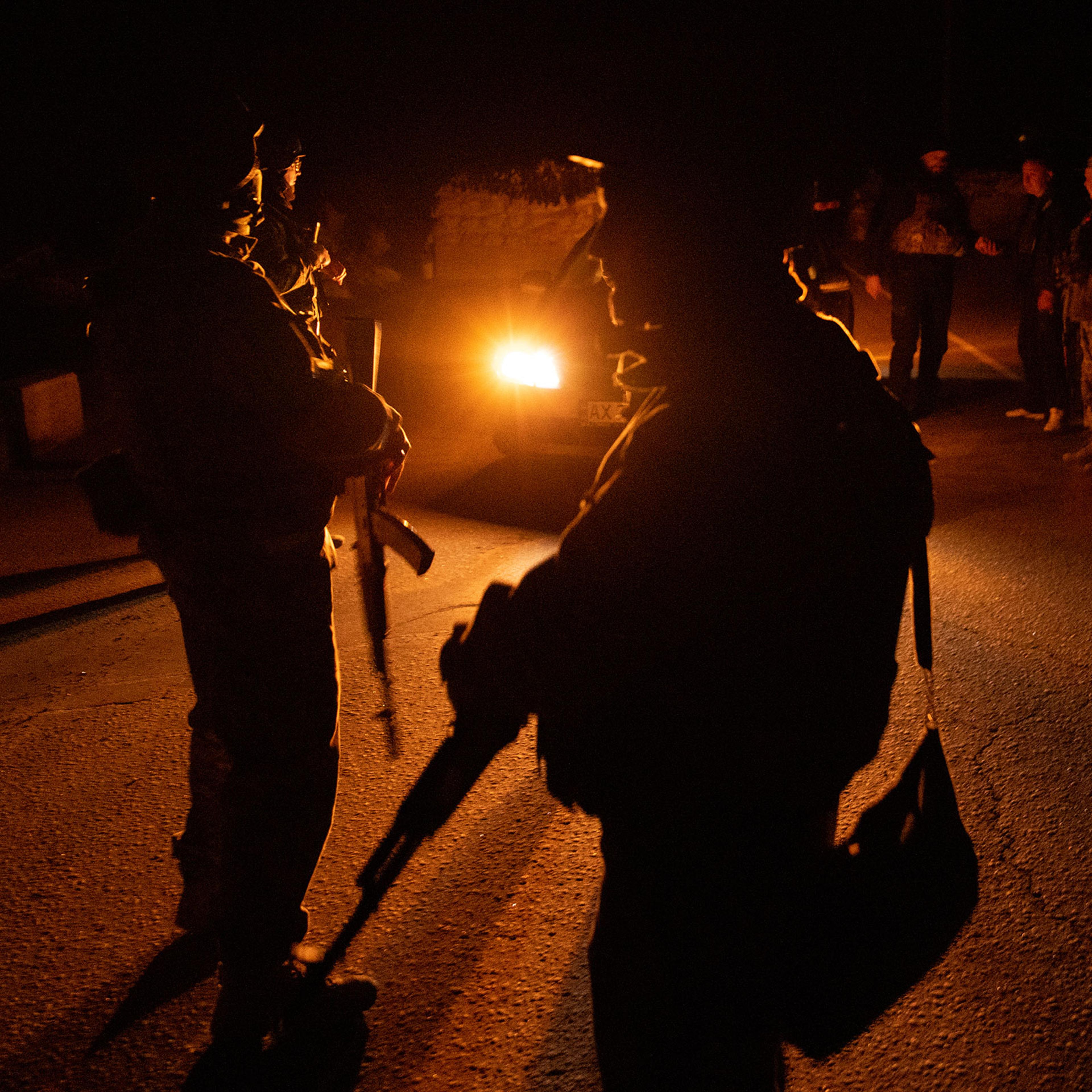 Members of the Territorial Defense Force brigade search vehicles after curfew on a road on the outskirts of Kharkiv on April 4, 2022 in Kharkiv, Ukraine.