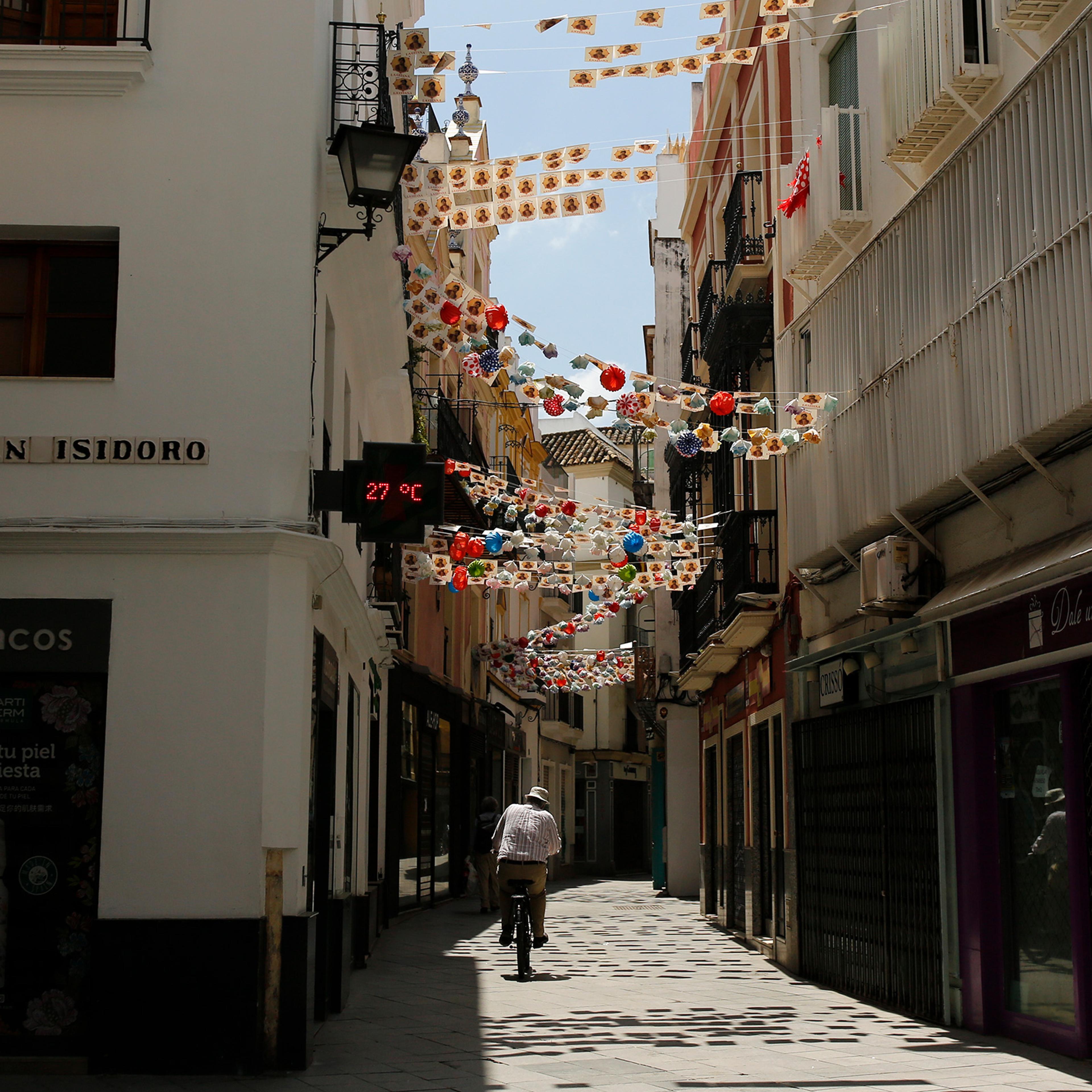 A man rides a bike along an empty street during a COVID-19 lockdown in Seville, Spain, on May 8, 2020.
