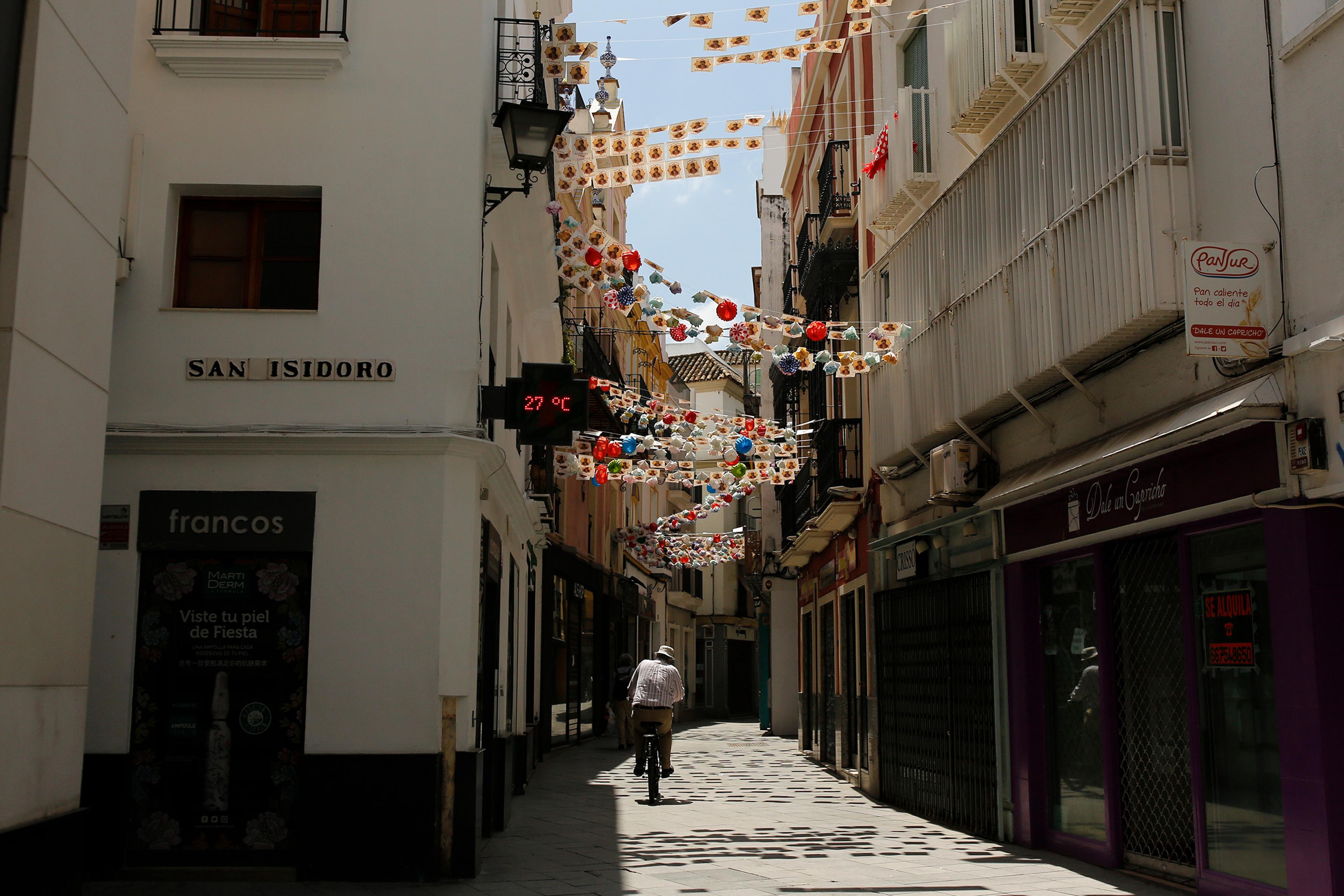 A man rides a bike along an empty street during a COVID-19 lockdown in Seville, Spain, on May 8, 2020.