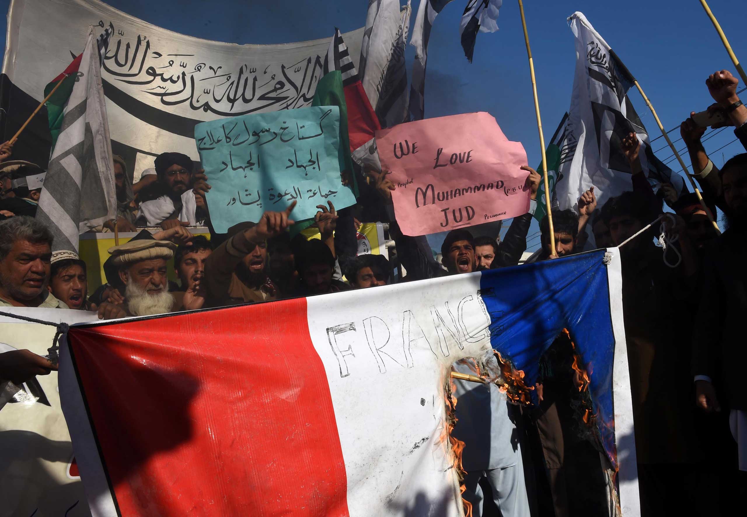 Pakistani protesters burn a French flag during a protest against the printing of satirical sketches of the Prophet Muhammad by French magazine Charlie Hebdo in Peshawar, Pakistan on Jan. 16, 2015.