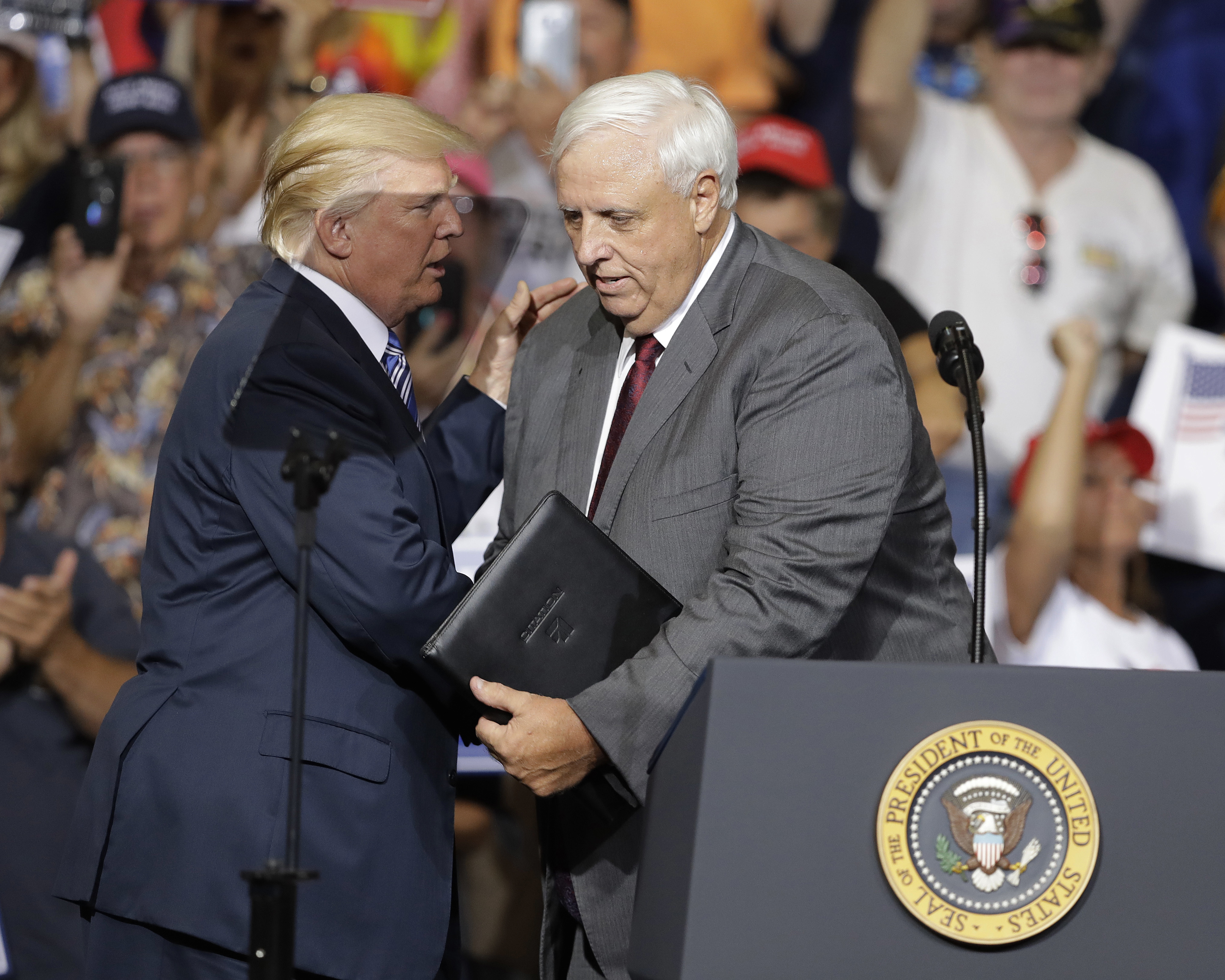 President Donald Trump talks with West Virginia Gov. Jim Justice during a rally Thursday, Aug. 3, 2017, in Huntington, W.Va. Justice, a Democrat, announced that he is switching parties to join the Republicans.