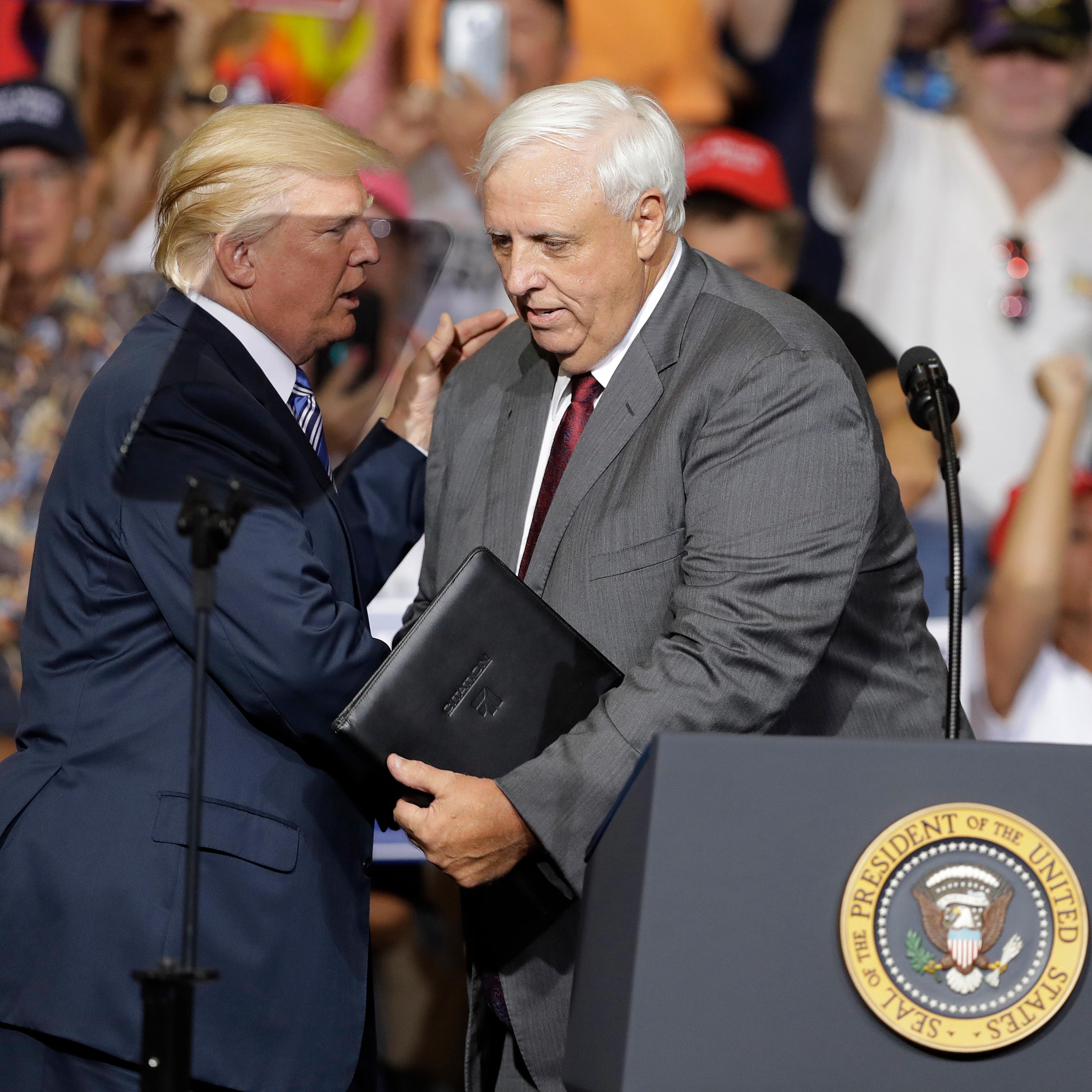President Donald Trump talks with West Virginia Gov. Jim Justice during a rally Thursday, Aug. 3, 2017, in Huntington, W.Va. Justice, a Democrat, announced that he is switching parties to join the Republicans.