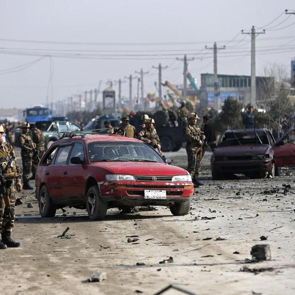 Afghan security forces inspect the site of a suicide attack on a British embassy vehicle in Kabul