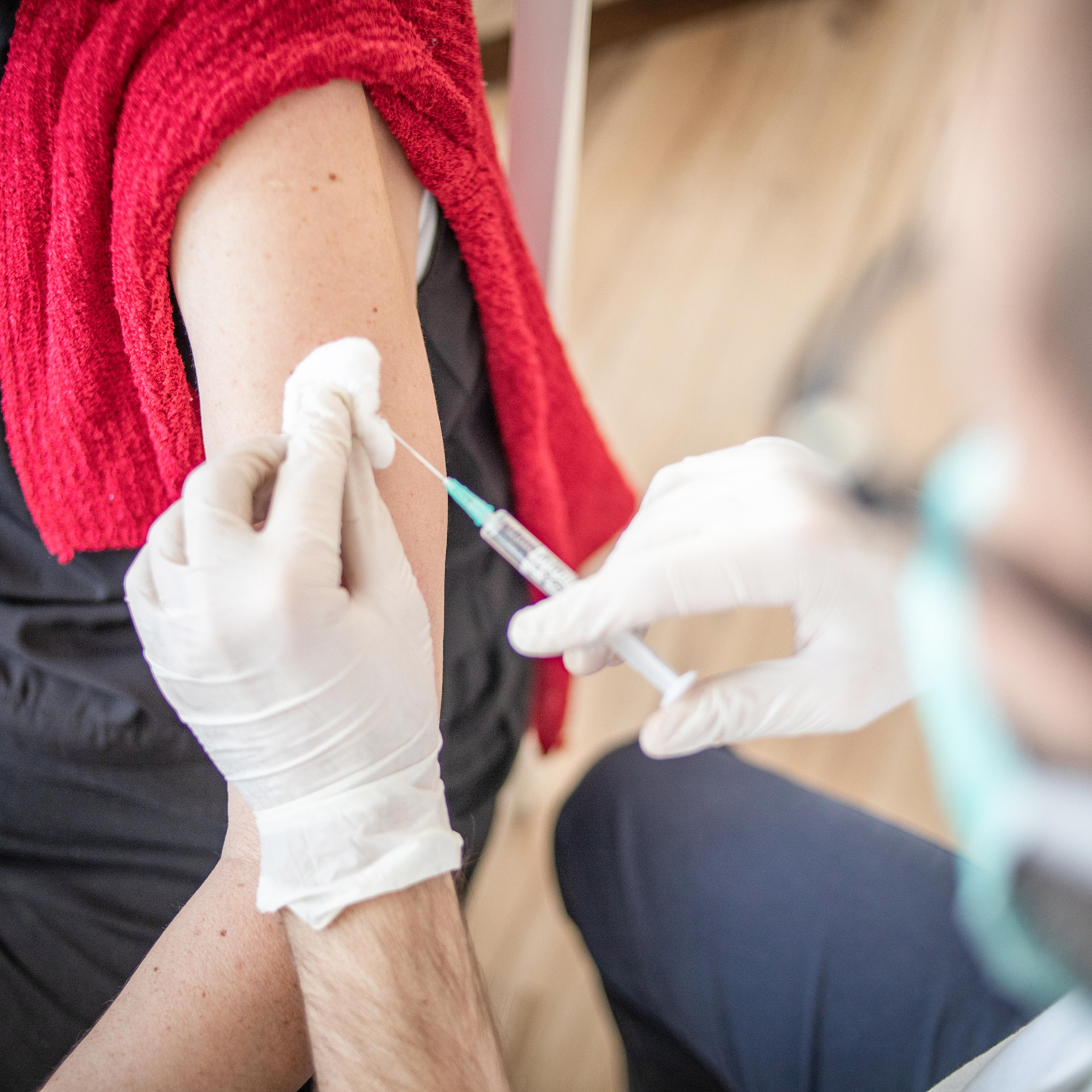 Booster dose vaccine Covid 19. The doctor gives the vaccine to an older woman.