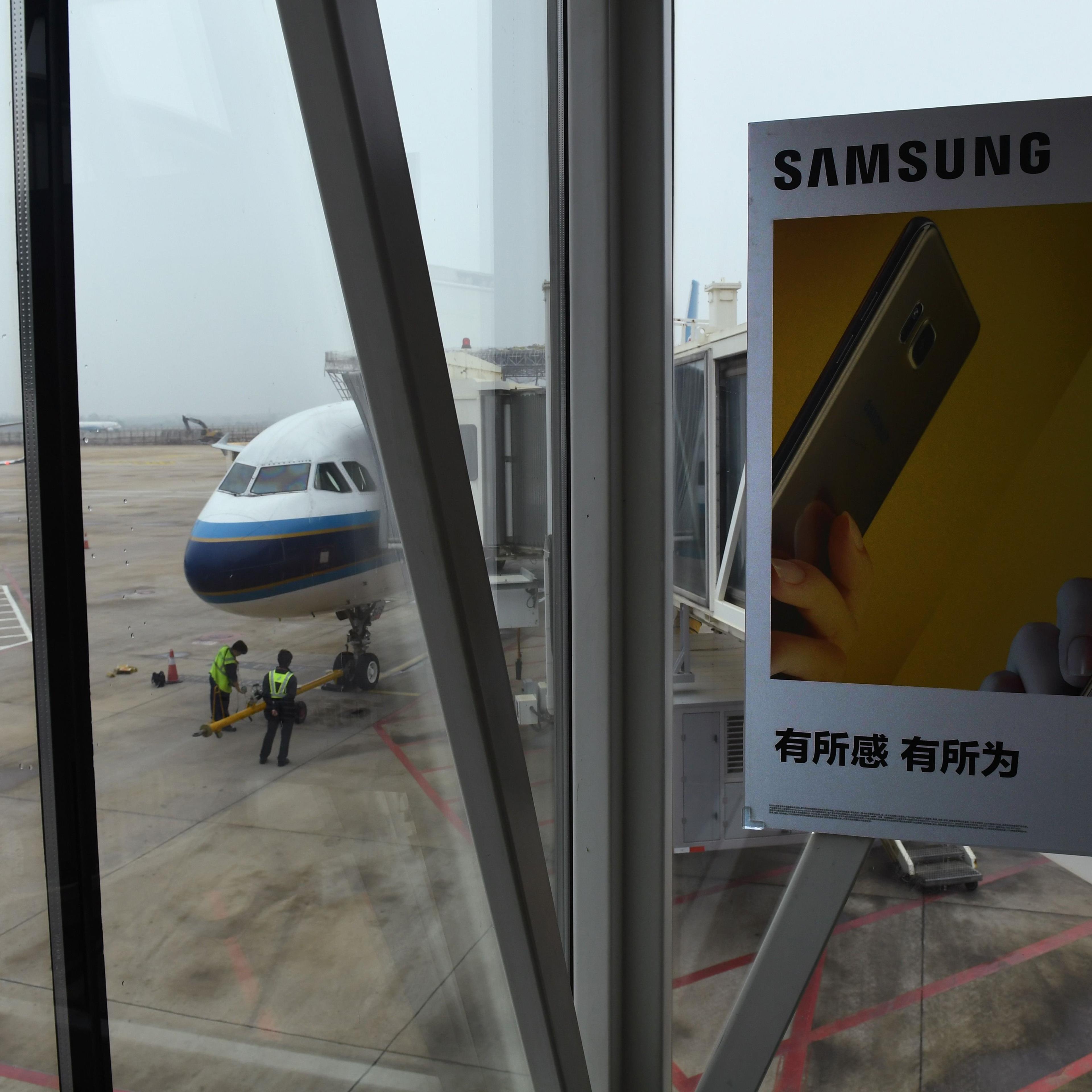An advertisement for the Samsung Galaxy Note 7 smartphone is seen on an air bridge leading to a plane at the airport in Wuhan, in China's central Hubei province on October 2, 2016. Signs at the Wuhan airport check-in counters warn passengers not to switc