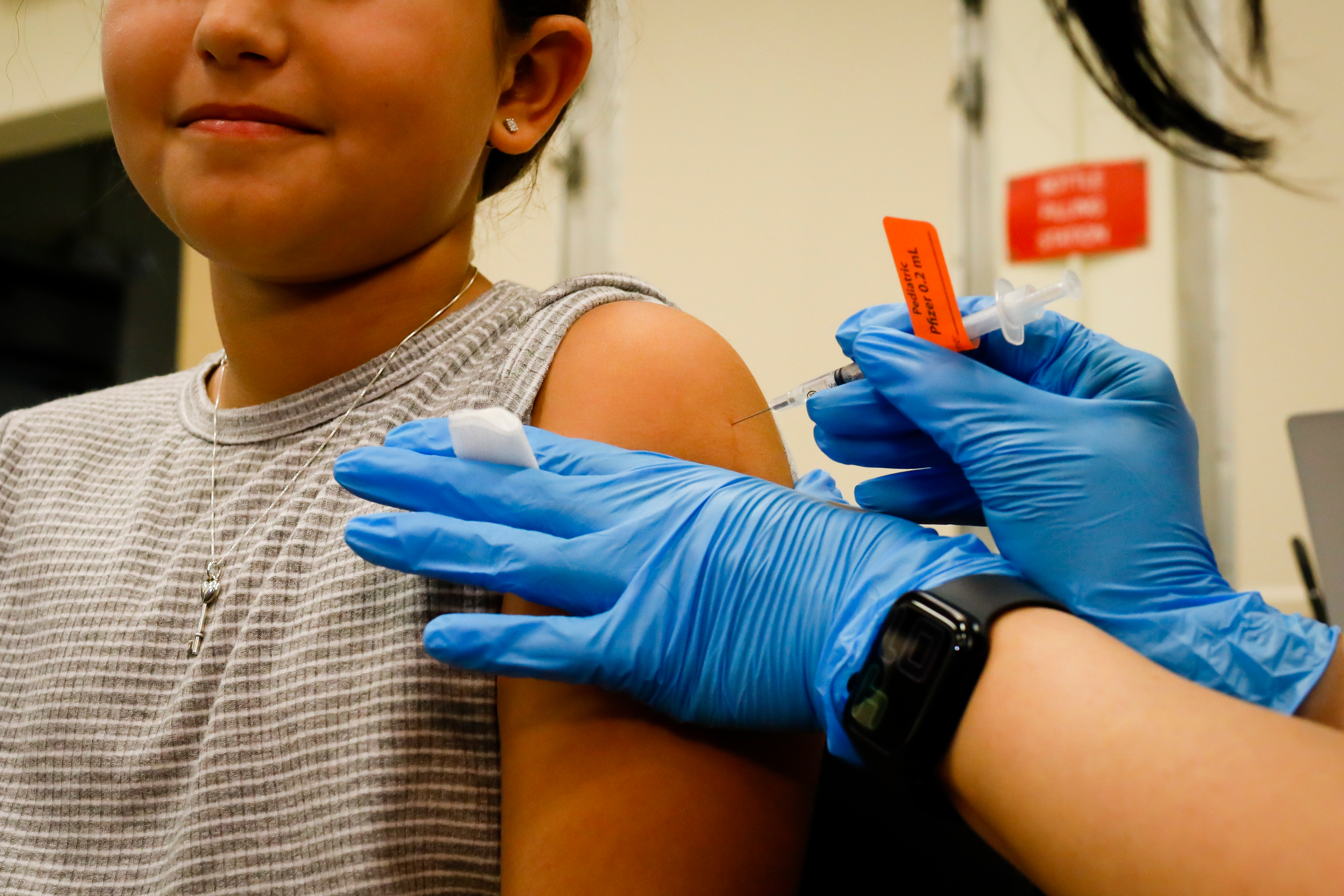 A child receives a dose of the Pfizer-BioNTech COVID-19 vaccine at an elementary school vaccination site for children ages 5 to 11-year-old in Miami, on Nov. 22, 2021.
