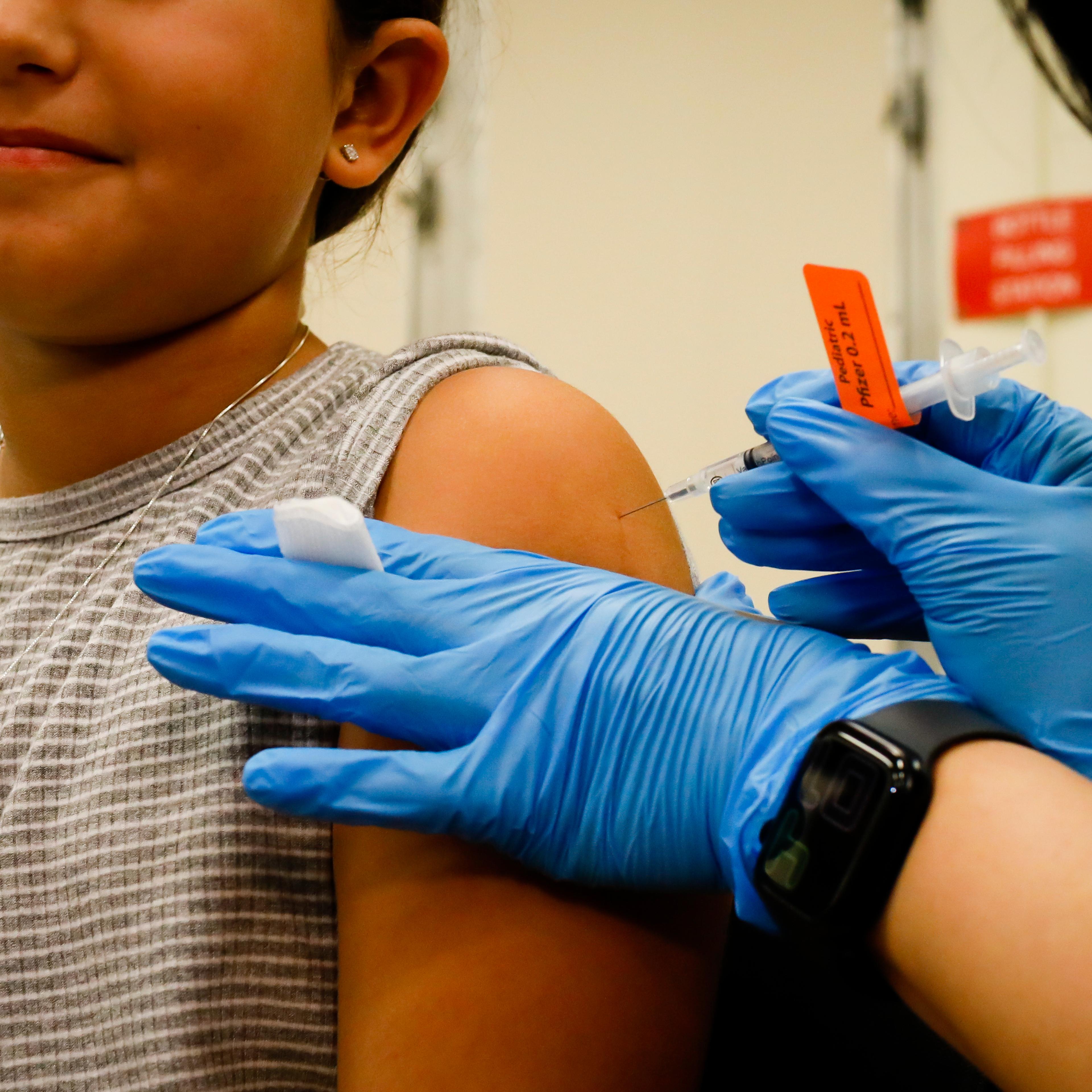 A child receives a dose of the Pfizer-BioNTech COVID-19 vaccine at an elementary school vaccination site for children ages 5 to 11-year-old in Miami, on Nov. 22, 2021.