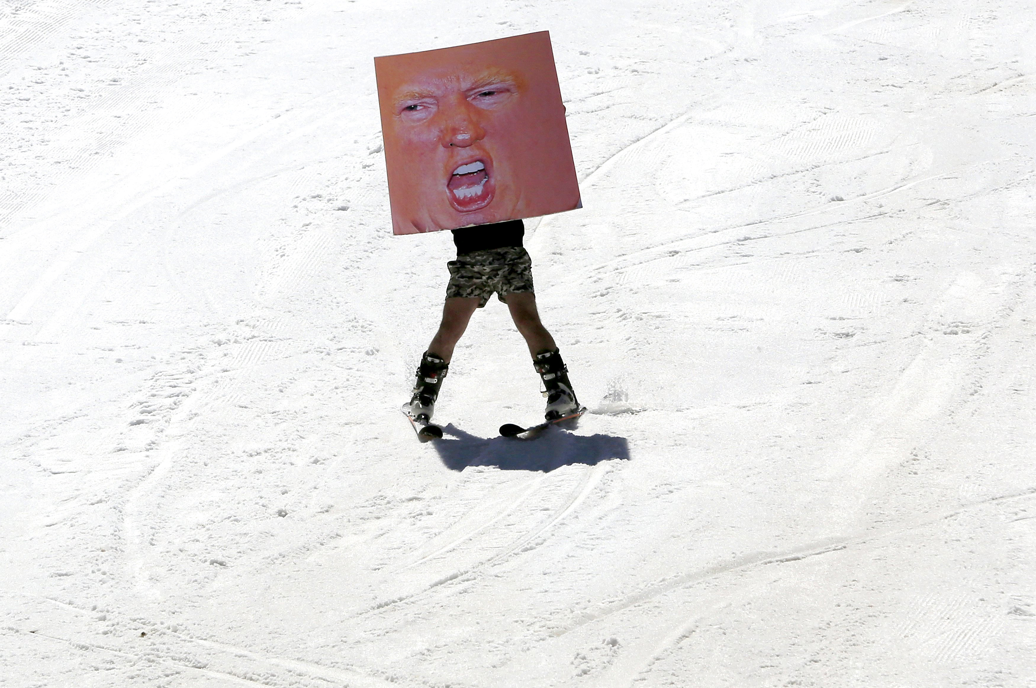 A man holds a poster depicting Donald Trump while participating in Red Bull Jump &amp; Freeze Lebanon at a ski resort in mount Lebanon on Feb. 28.