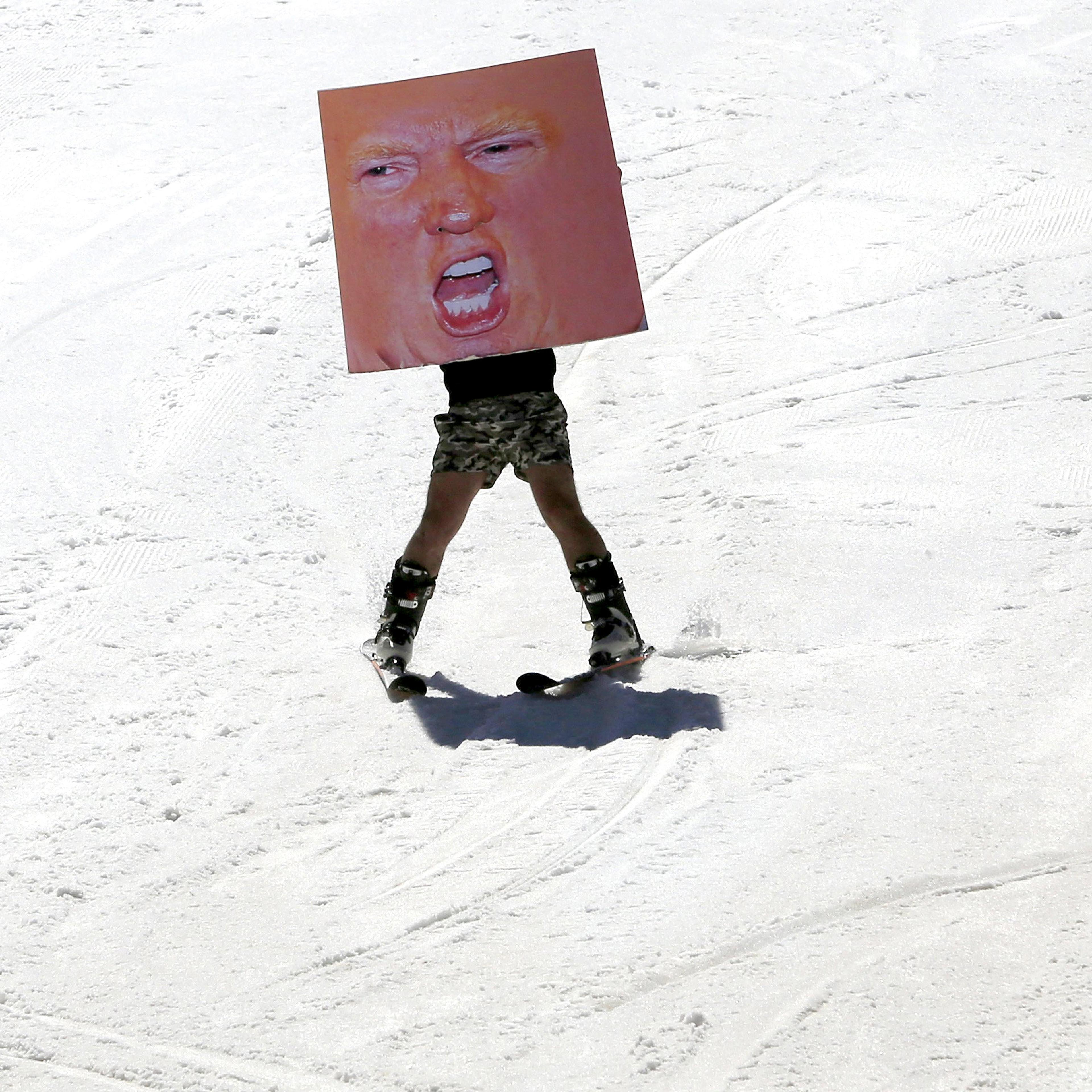 A man holds a poster depicting Donald Trump while participating in Red Bull Jump & Freeze Lebanon at a ski resort in mount Lebanon on Feb. 28.