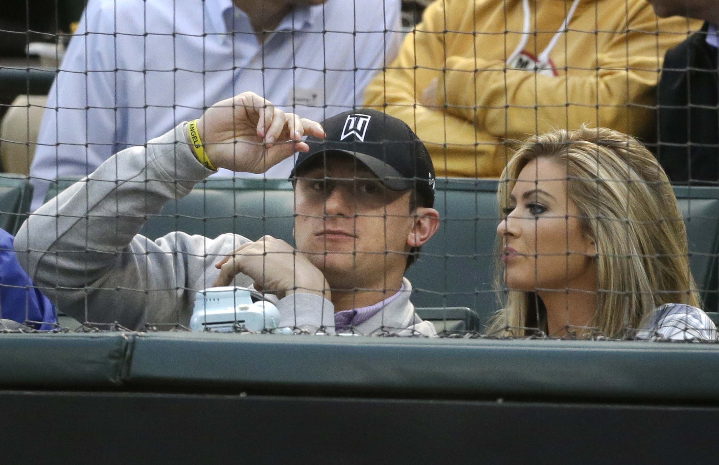 Johnny Manziel sits with Colleen Crowley during a baseball game between the Los Angeles Angels and the Texas Rangers in Arlington, Texas on April 14, 2015.