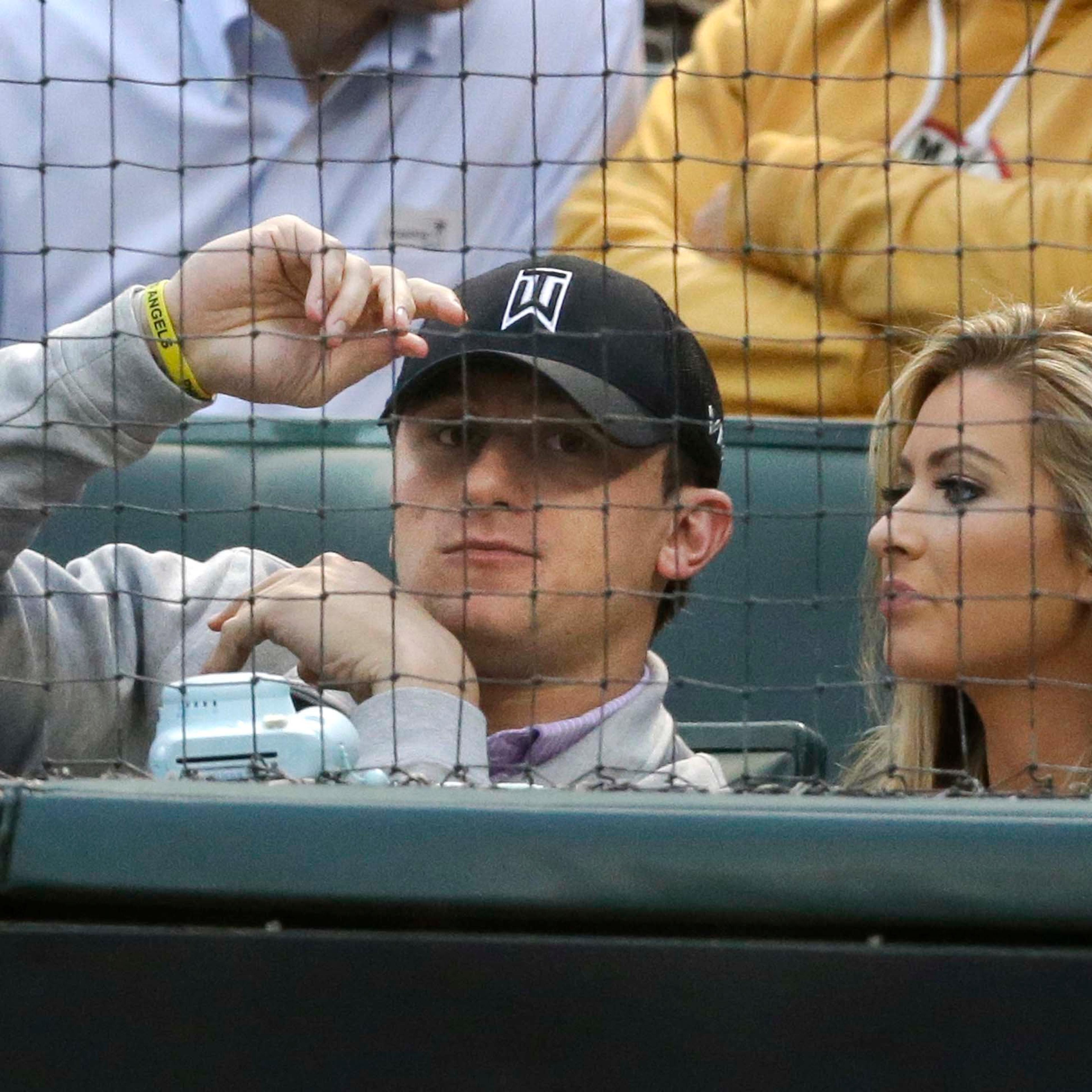 Johnny Manziel sits with Colleen Crowley during a baseball game between the Los Angeles Angels and the Texas Rangers in Arlington, Texas on April 14, 2015.