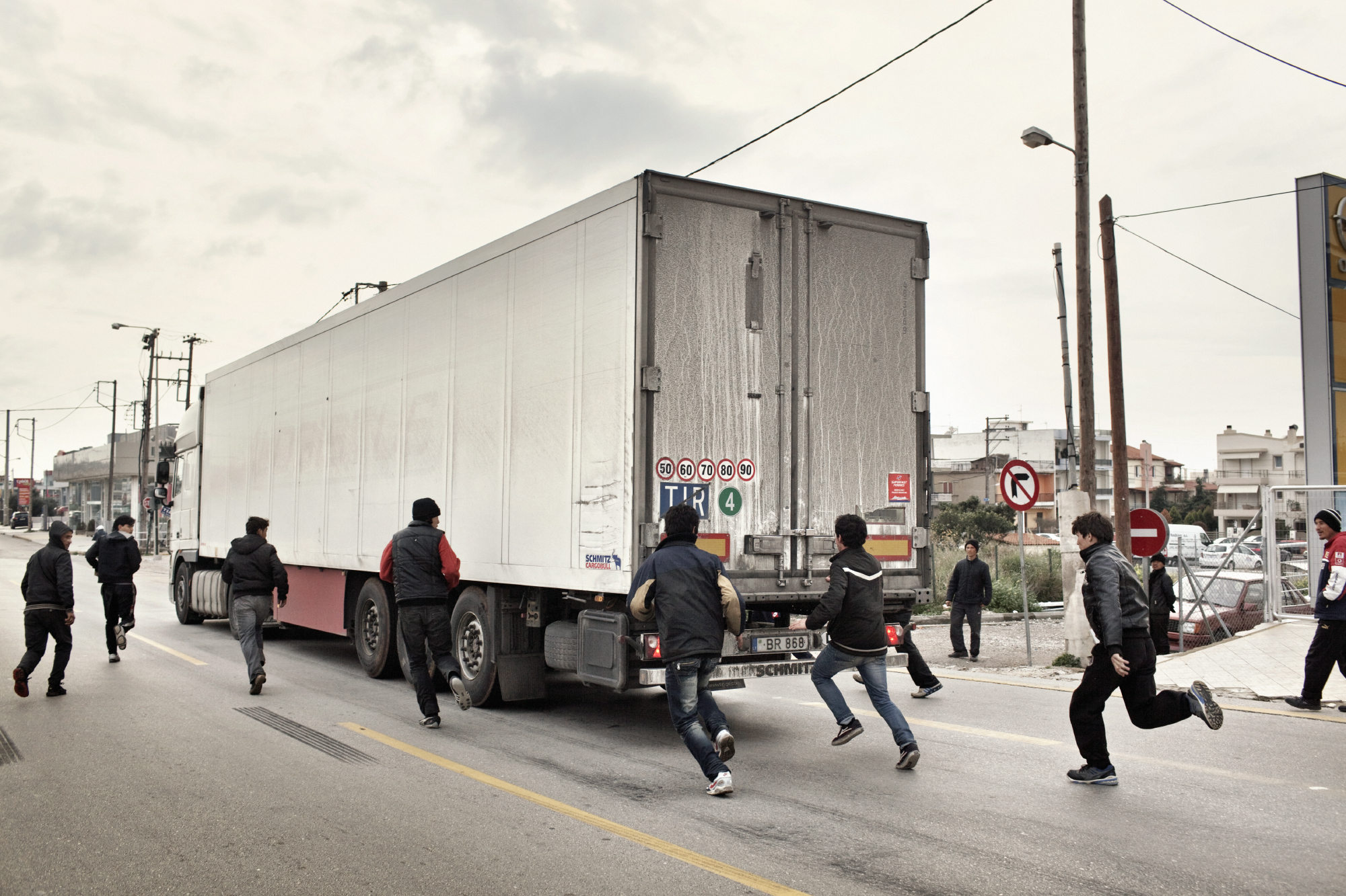 2012. Patras. Greece. A group of adolescents trying to illegally board trucks going to Italy.A group of Afghan boys aged 14 to 18 years, on a traffic island. Every day, these kids try to illegally board trucks going towards Italy. One of the most common 