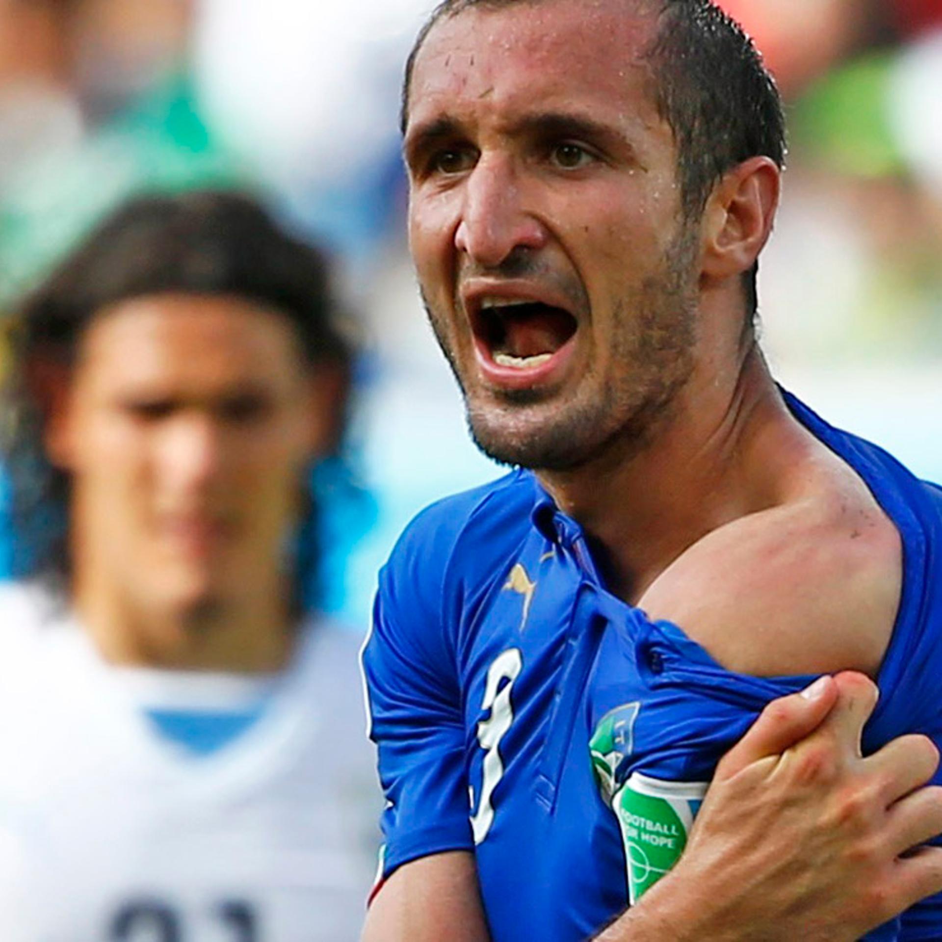 Italy's Giorgio Chiellini shows his shoulder, claiming he was bitten by Uruguay's Luis Suarez, during their 2014 World Cup Group D soccer match at the Dunas arena in Natal