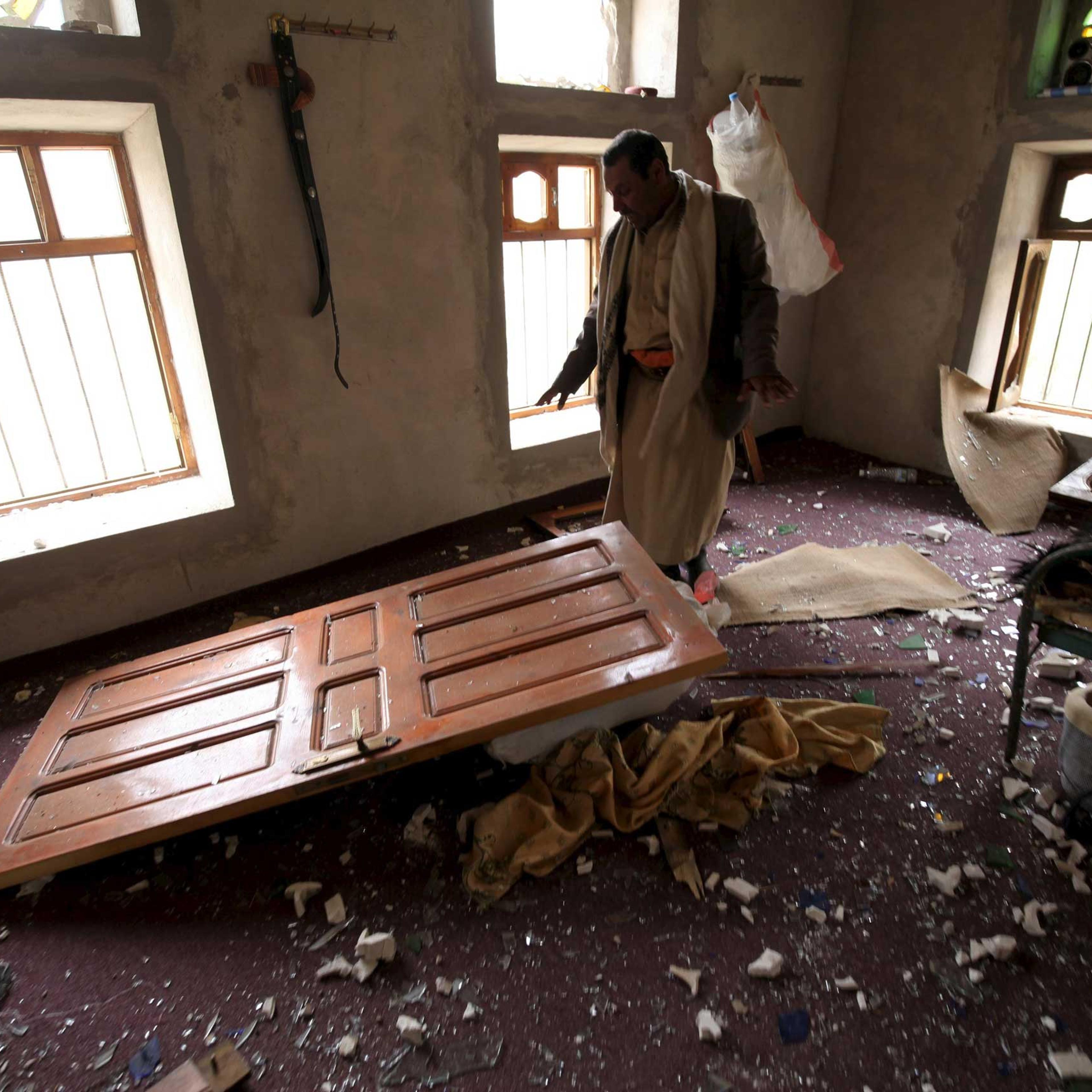 A man shows the damage inside his house after an air strike in the Okash village near Sanaa