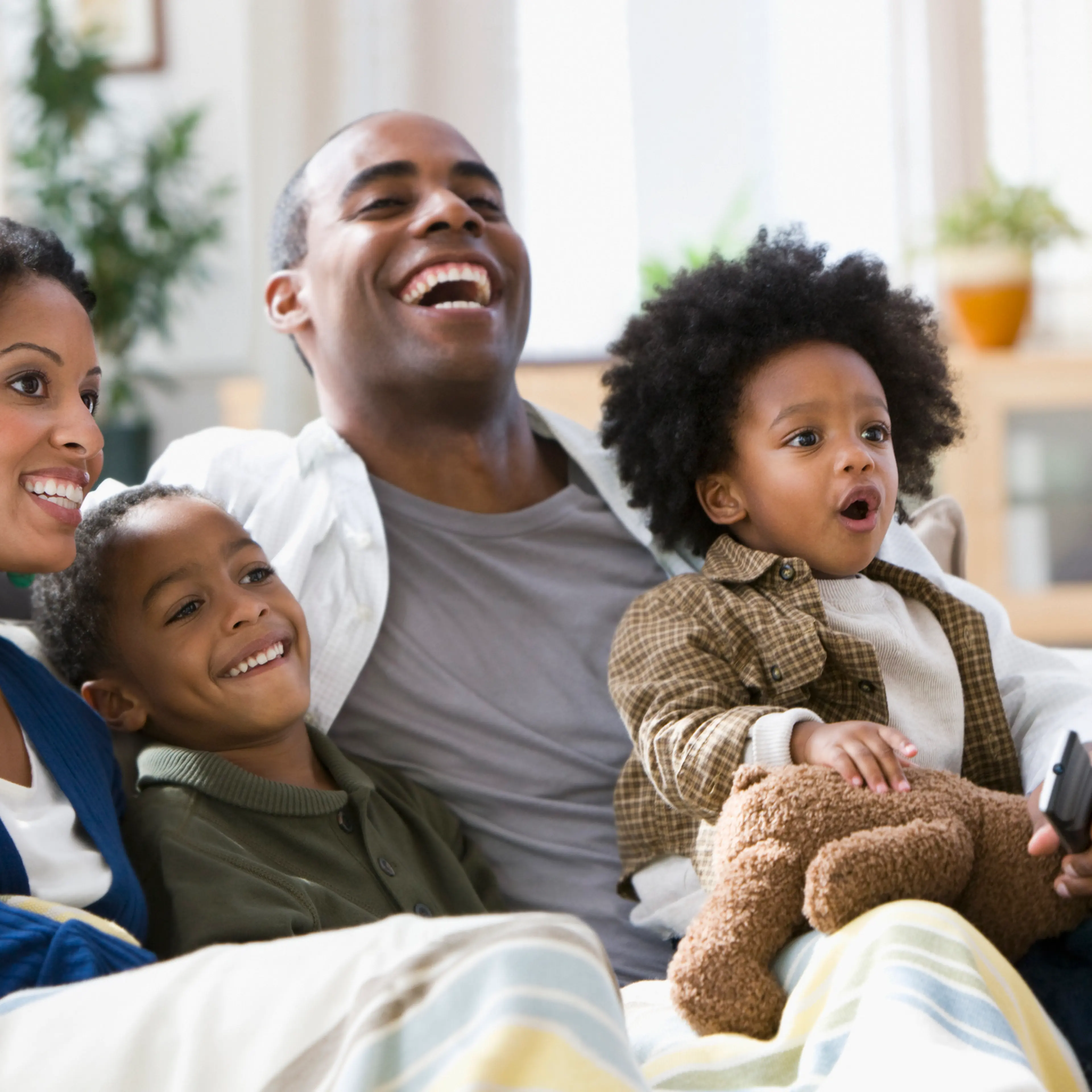African American family watching television together