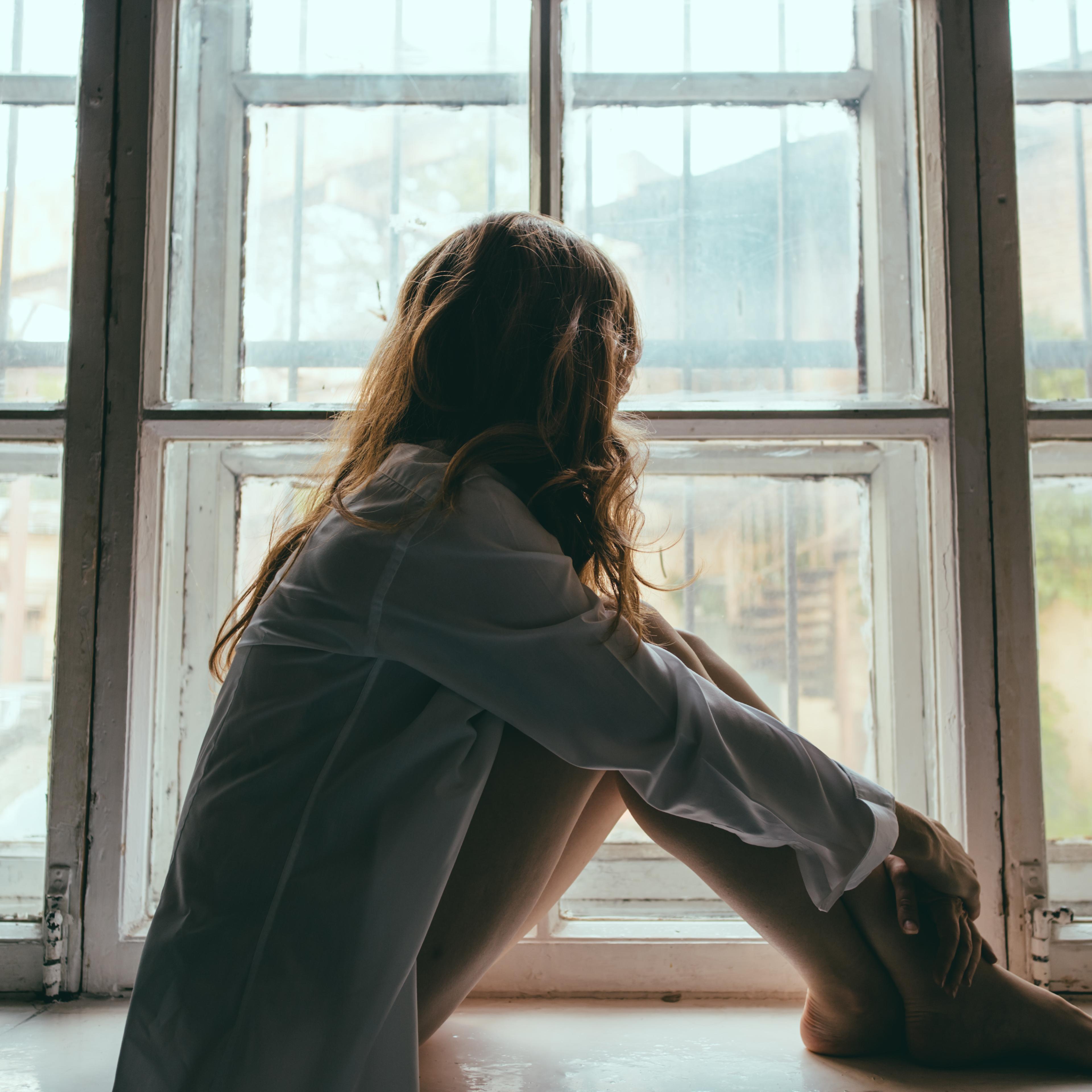 Woman Looking Through Window