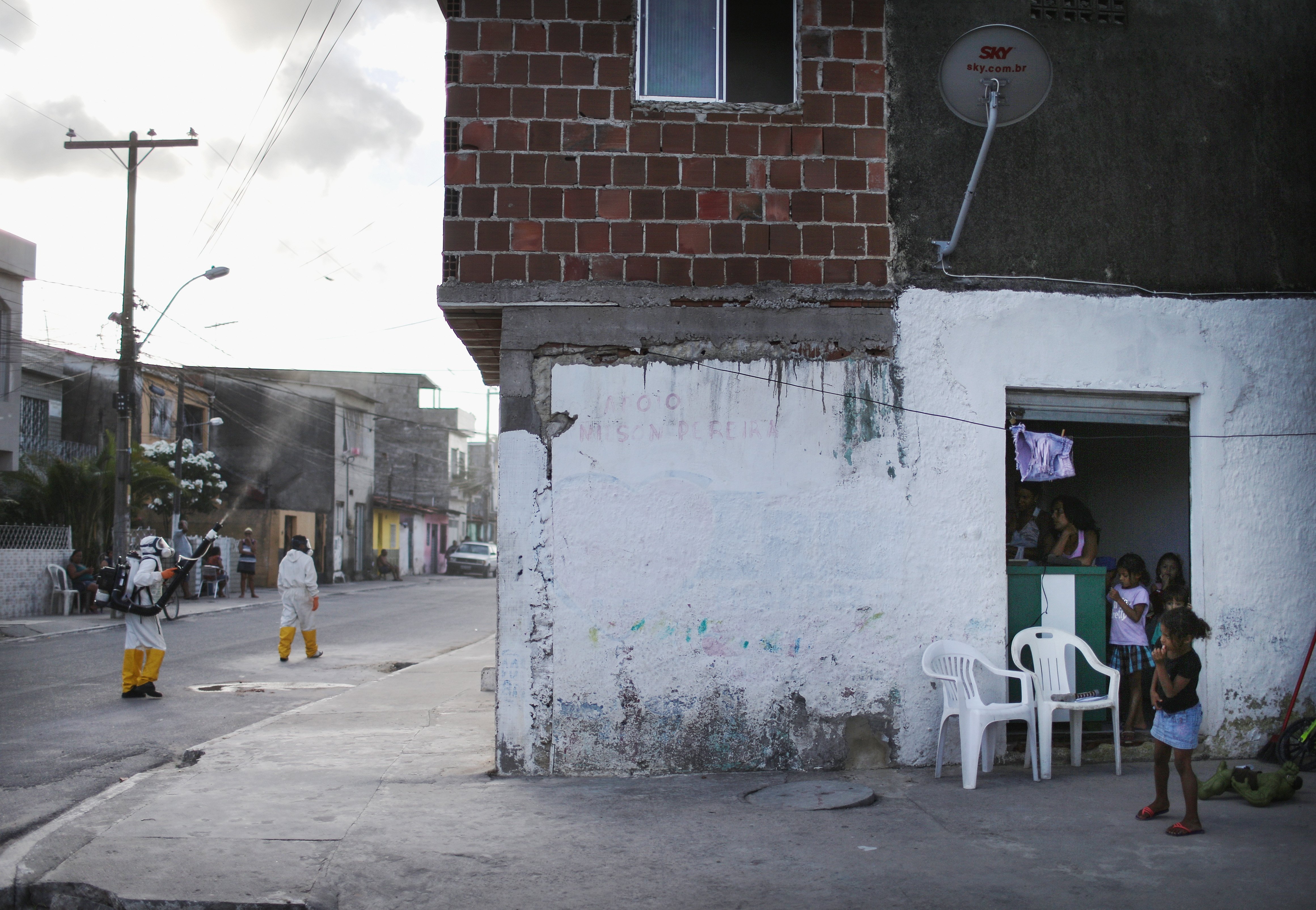 Girls gather nearby as health workers fumigate against the mosquito that transmits the Zika virus in Recife, Brazil, Jan. 28, 2016. Health officials believe as many as 100,000 people have been exposed to the Zika virus in Recife, although most never deve
