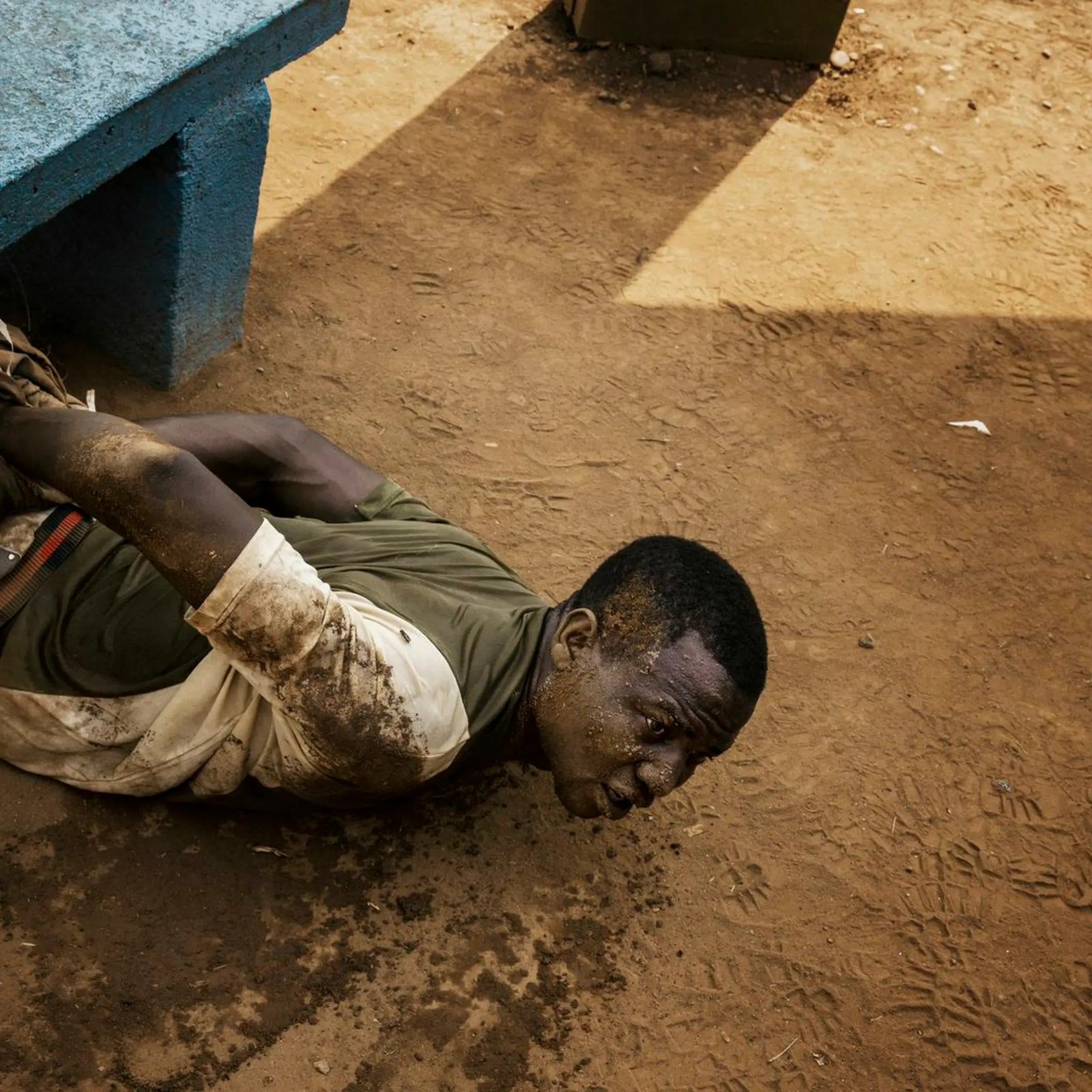 A man arrested by MISCA (Mission Internationale de Soutien a la Centrafrique Sous Conduite Africaine) soldiers lies on the ground with his wrists tied. He was found with a grenade in a pocket. Bangui, Central African Republic.