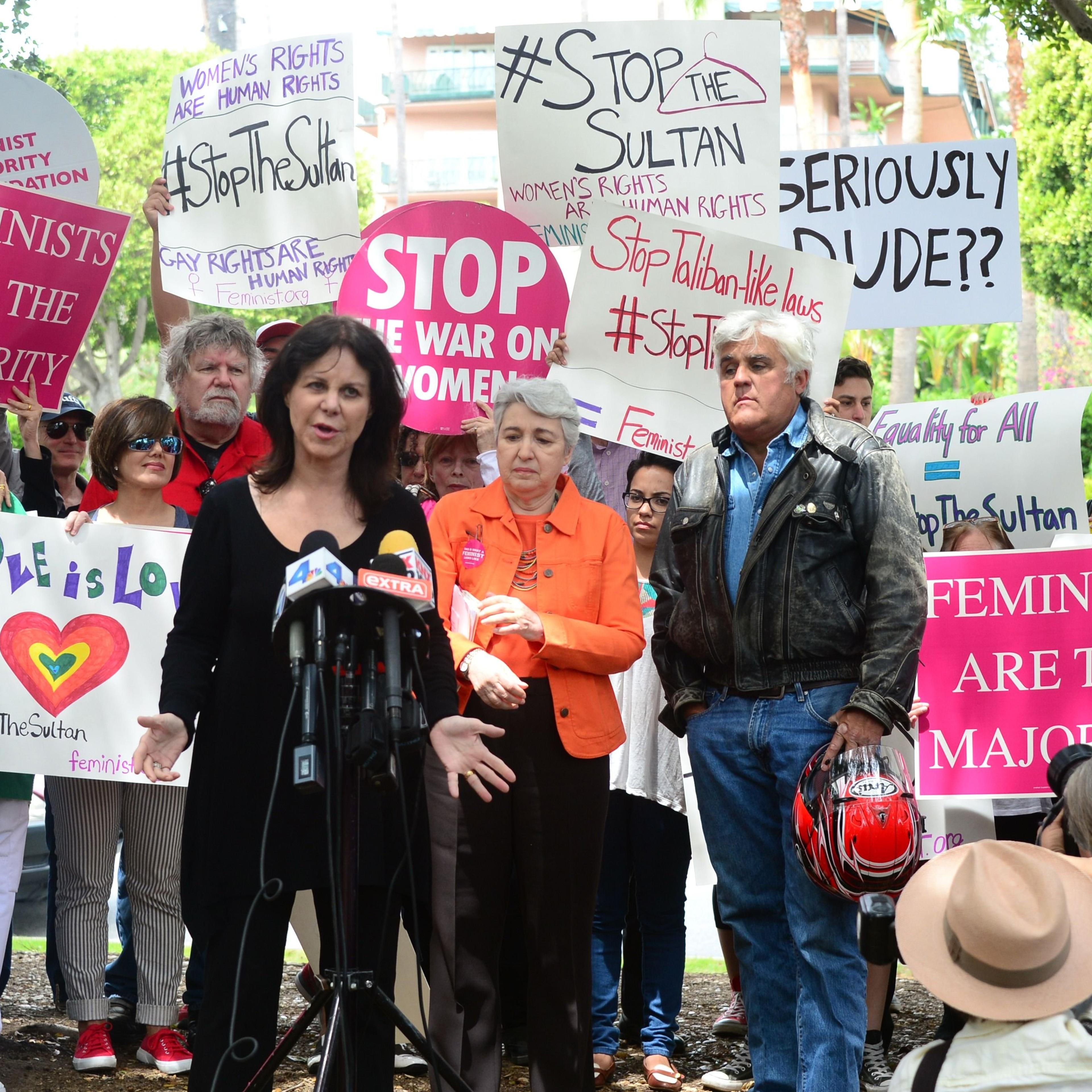 Jay Leno watches as his wife Mavis speaks to supporters of women's rights and LGBT groups at a protest across from the Beverly Hills Hotel, owned by the Sultan of Brunei, on May 5, 2014 in Beverly Hills, Calif.