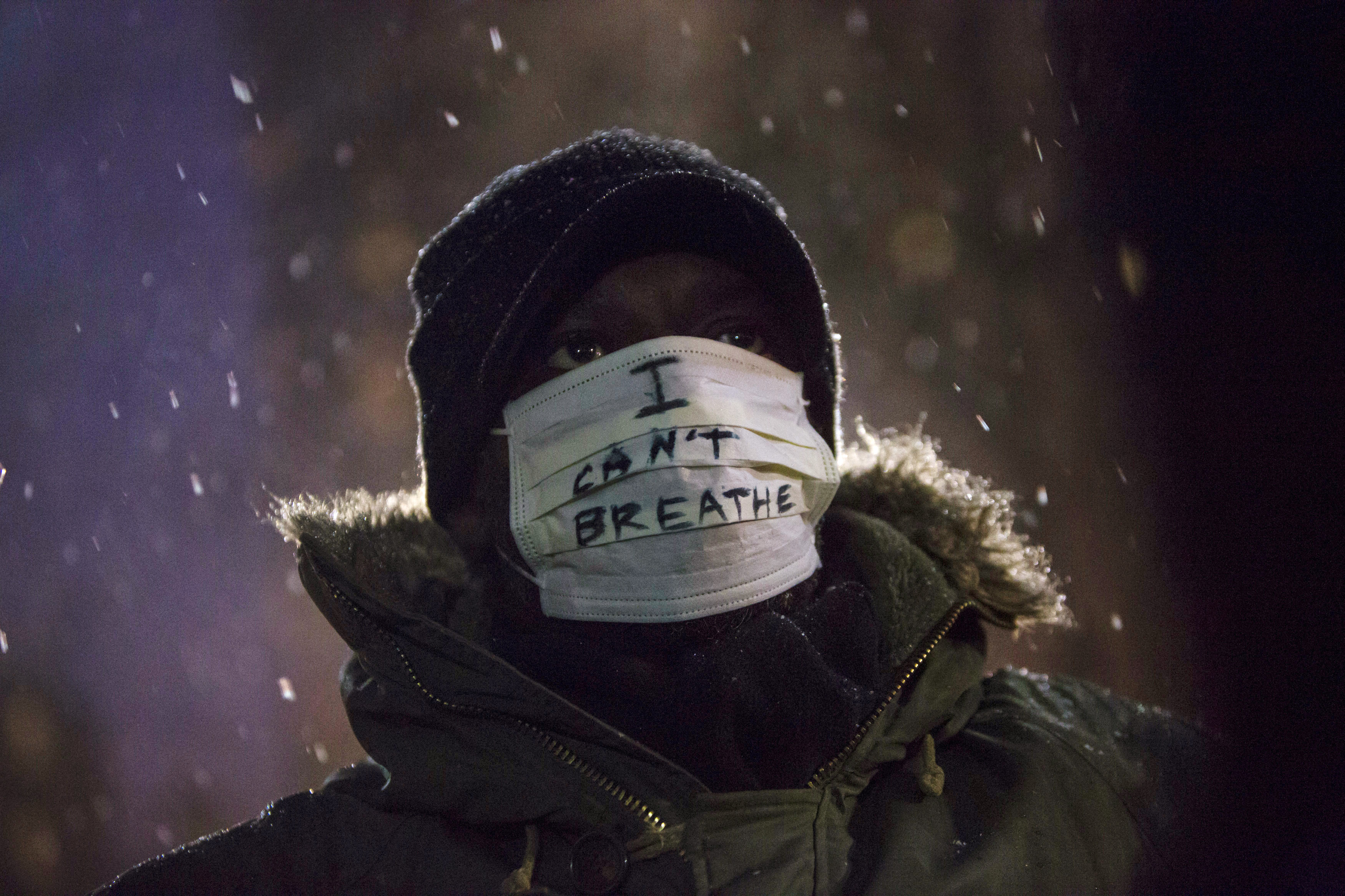 A man stands in falling snow following a news conference where members of Justice League NYC presented a list of demands in New York