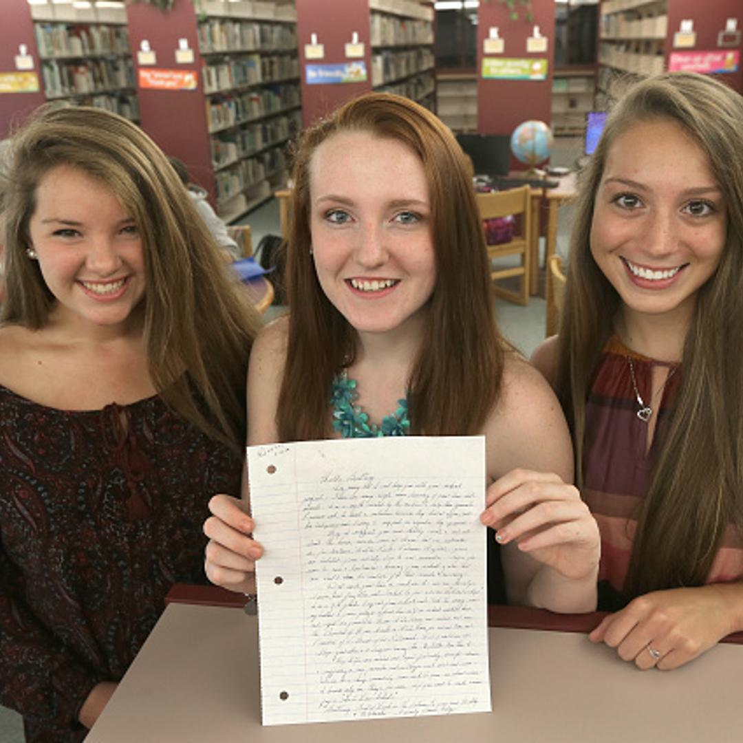 Apponequet Regional High School students, Mollykate Rodenbush, Brittany Tainsh, and Michaela Arguin (from left), hold the handwritten reply from Whitey Bulger.