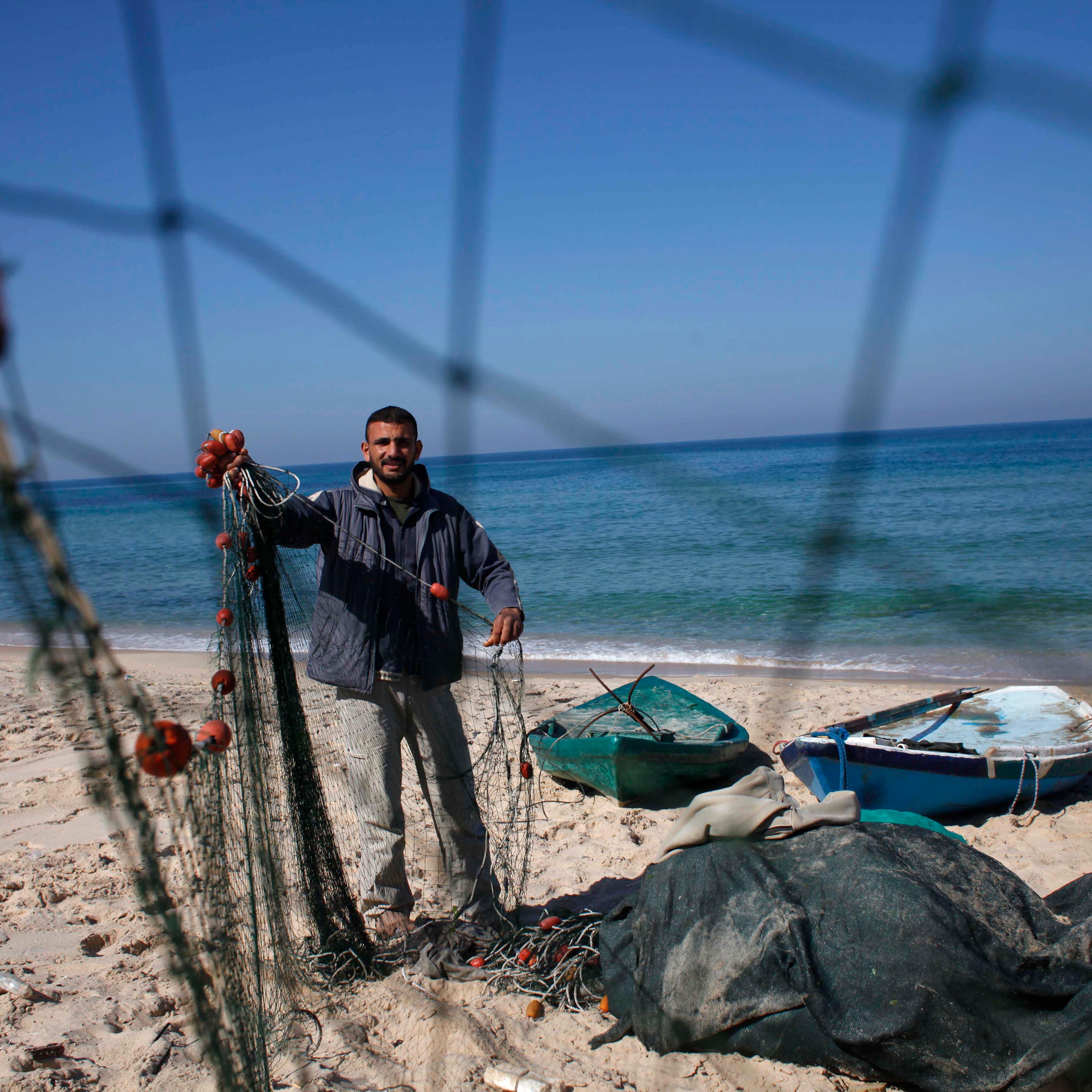 Palestinian fisherman Joudat Ghrab, who said he scooped a 500-kg bronze statue of the Greek God Apollo from the sea bed last August, prepares his fishing net in the central Gaza Strip