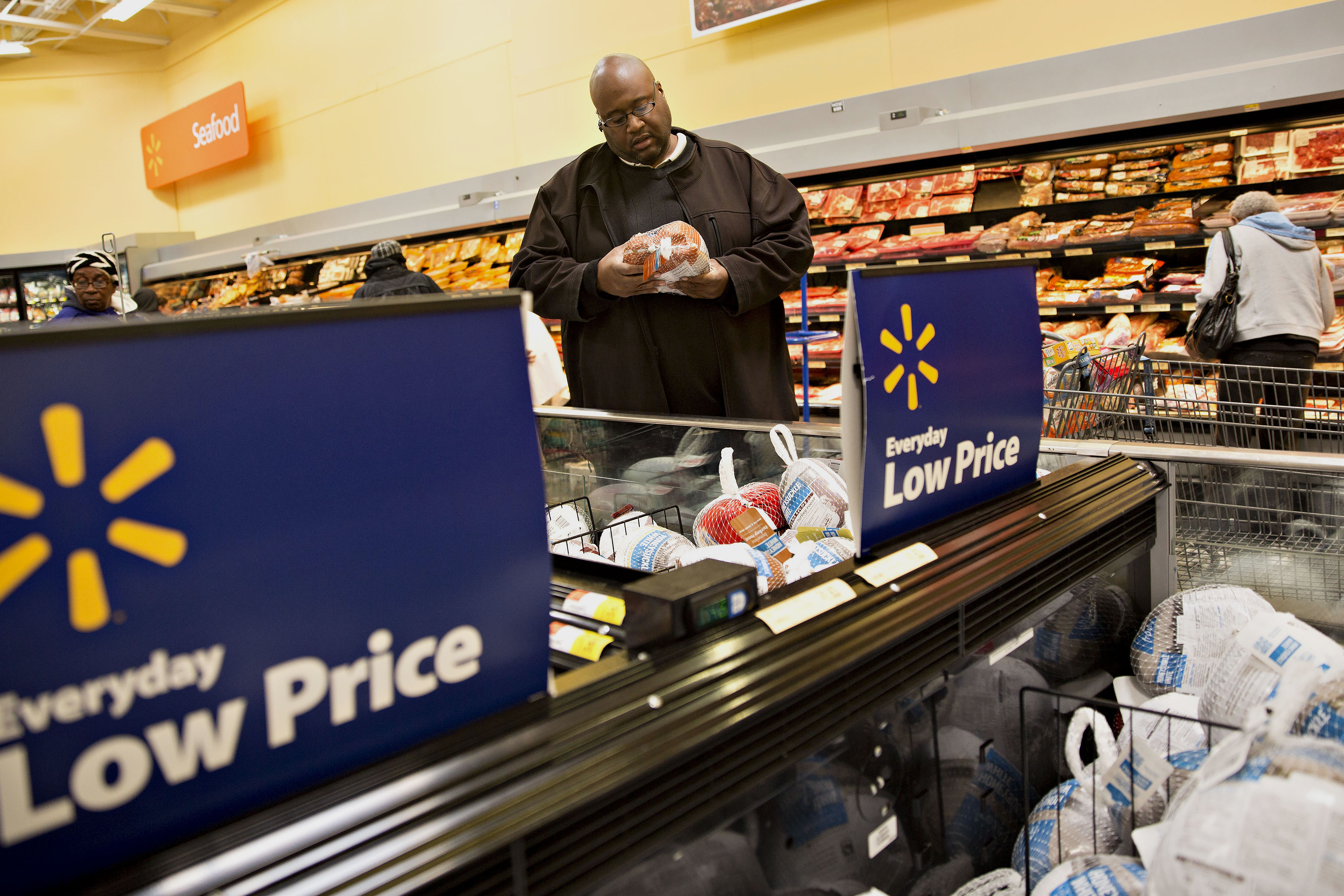 A shopper looks over a hickory-smoked turkey at a Wal-Mart Stores Inc. location in Chicago, Nov. 25, 2015.