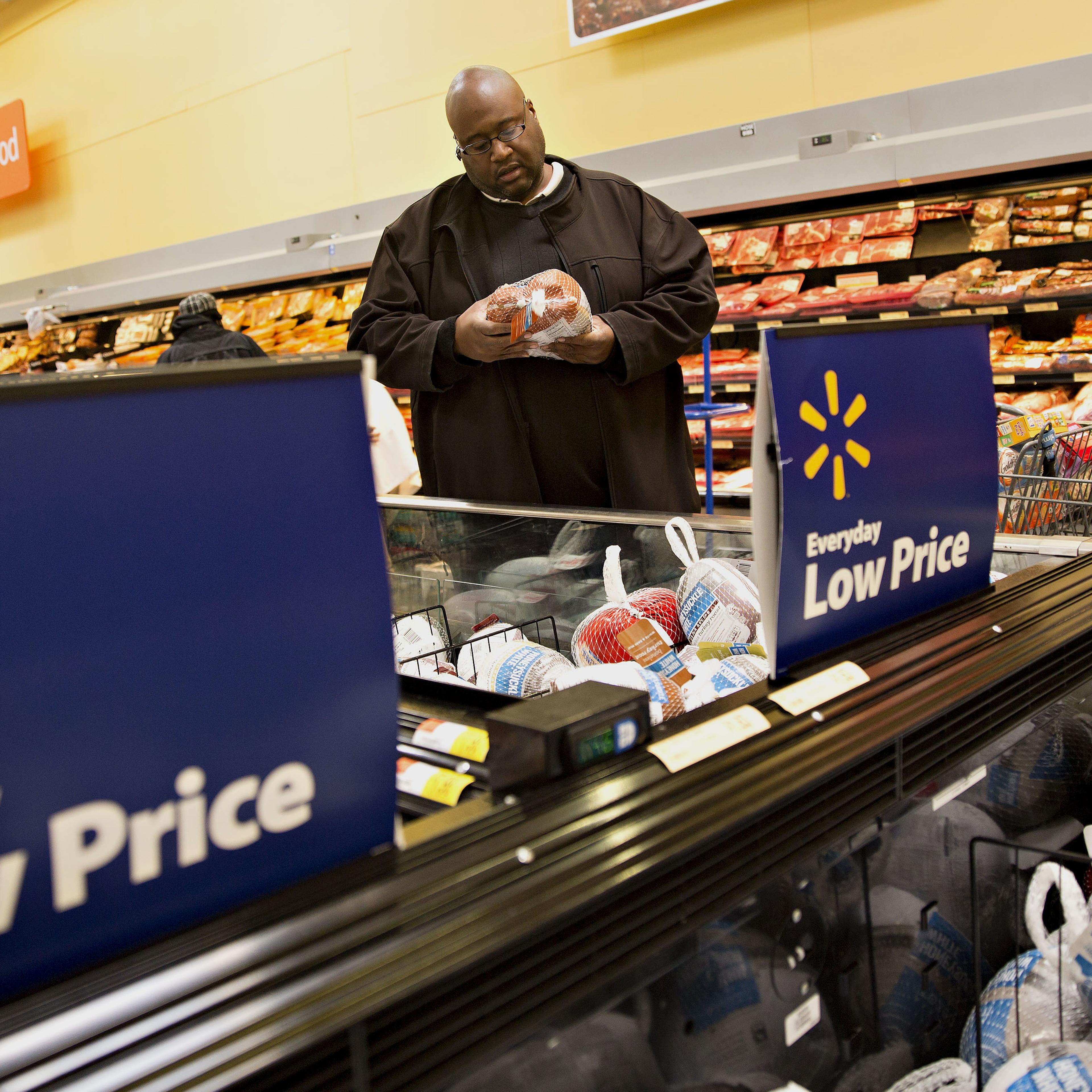 A shopper looks over a hickory-smoked turkey at a Wal-Mart Stores Inc. location in Chicago, Nov. 25, 2015.