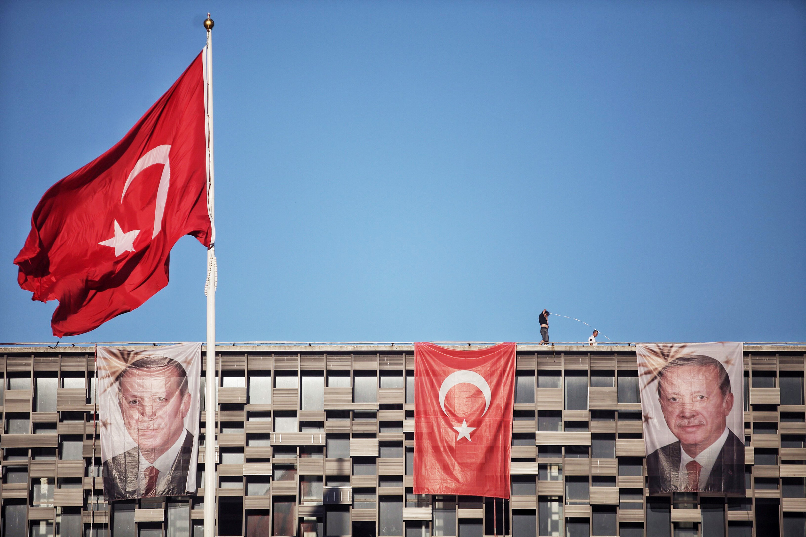 Posters of Turkey's President Recep Tayyip Erdogan and a Turkish flag hangs on Ataturk Cultural Center at Istanbul's central Taksim on July 19, 2016.