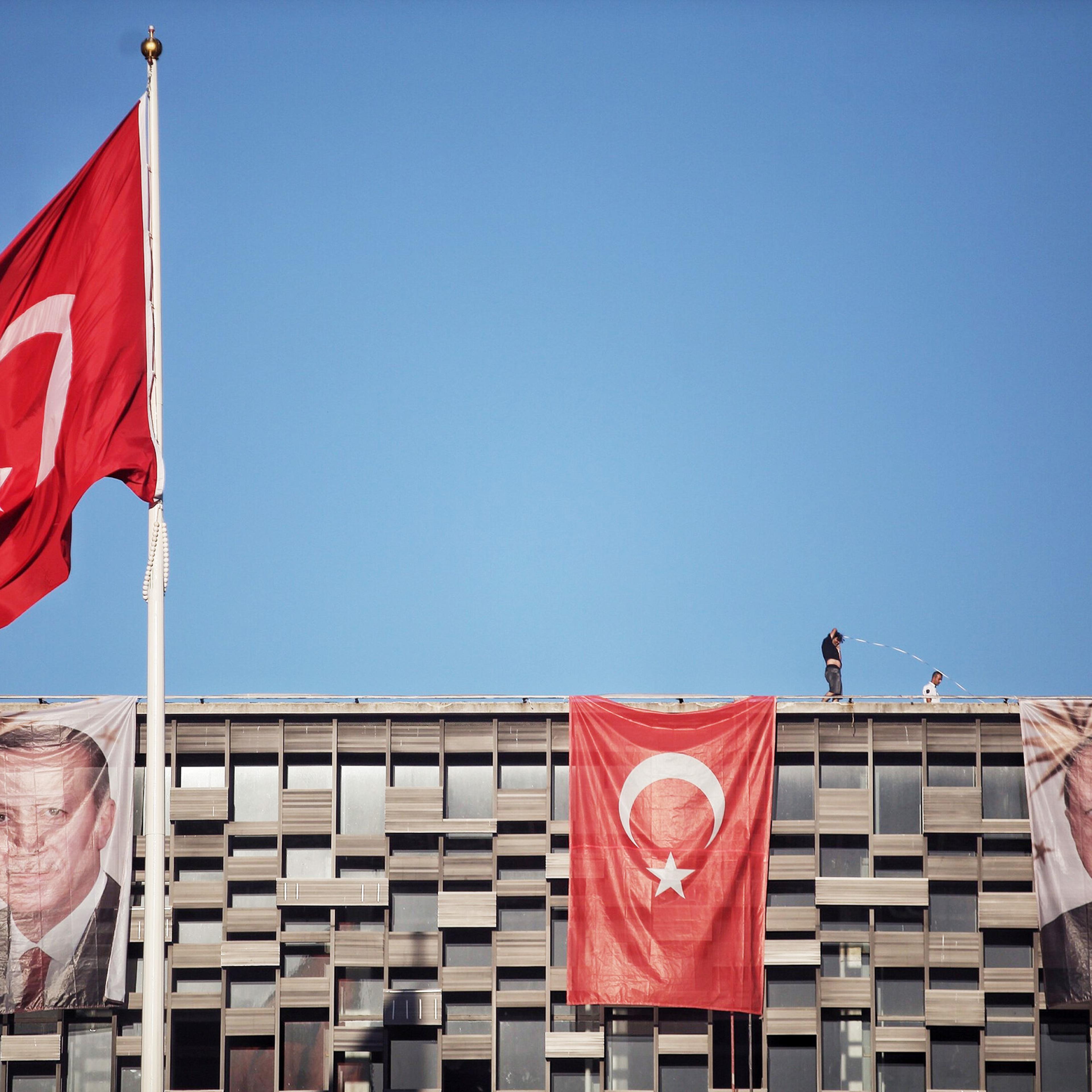 Posters of Turkey's President Recep Tayyip Erdogan and a Turkish flag hangs on Ataturk Cultural Center at Istanbul's central Taksim on July 19, 2016.