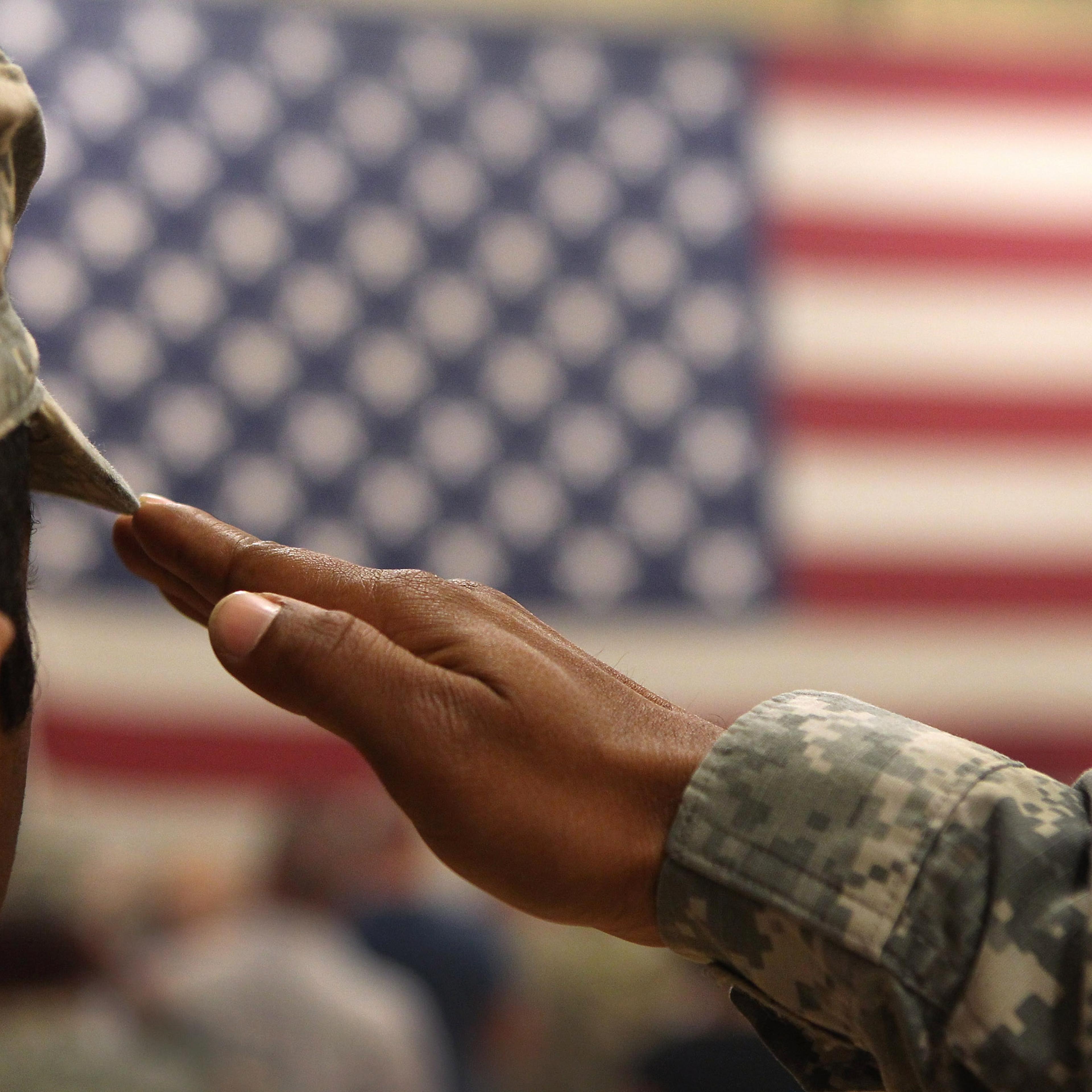 A soldier salutes the flag during a welcome home ceremony for troops arriving from Afghanistan on June 15, 2011 to Fort Carson, Colorado.