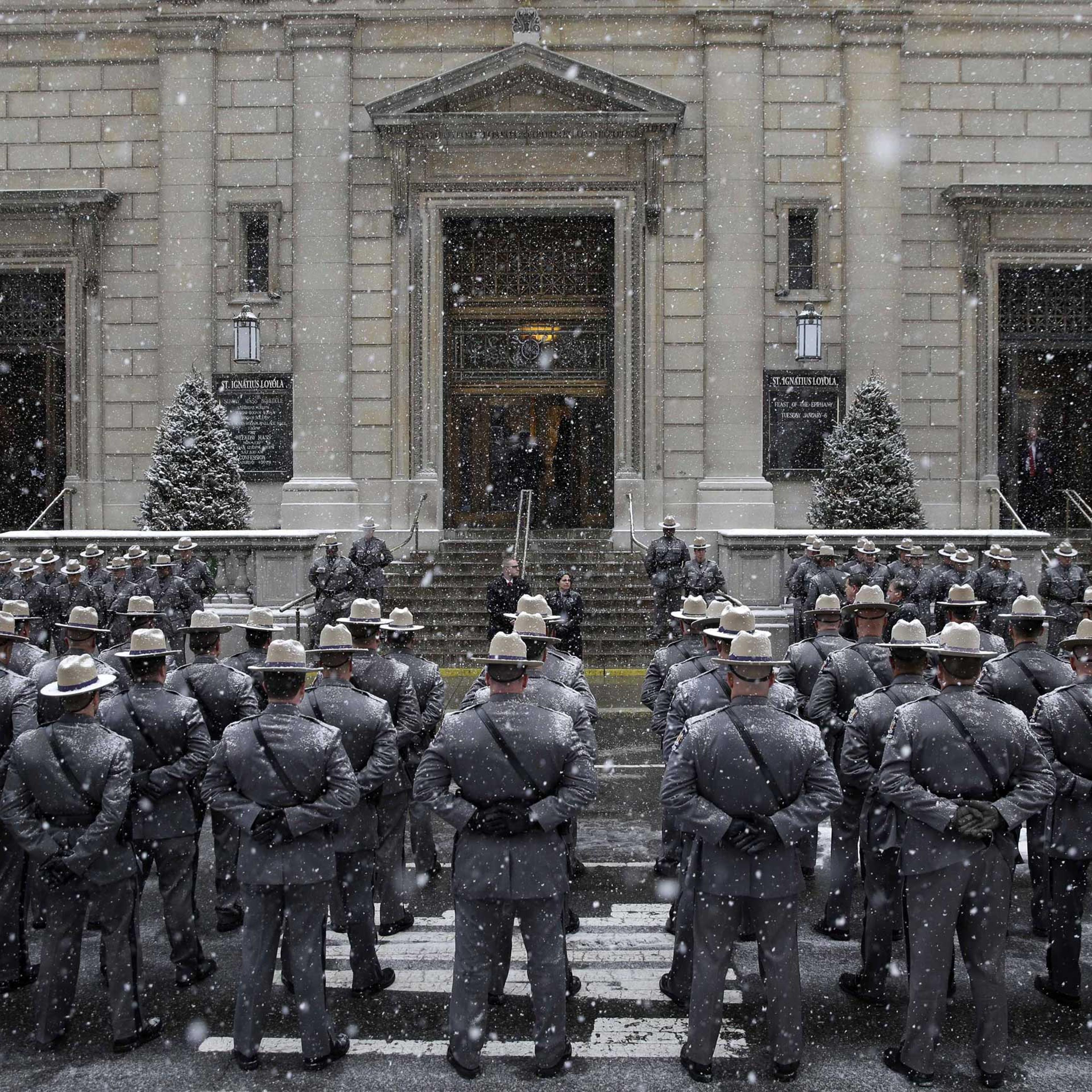State troopers stand at attention in the snow before the funeral for former New York governor Mario Cuomo at Church of St. Ignatius Loyola in New York on Jan. 6, 2015.