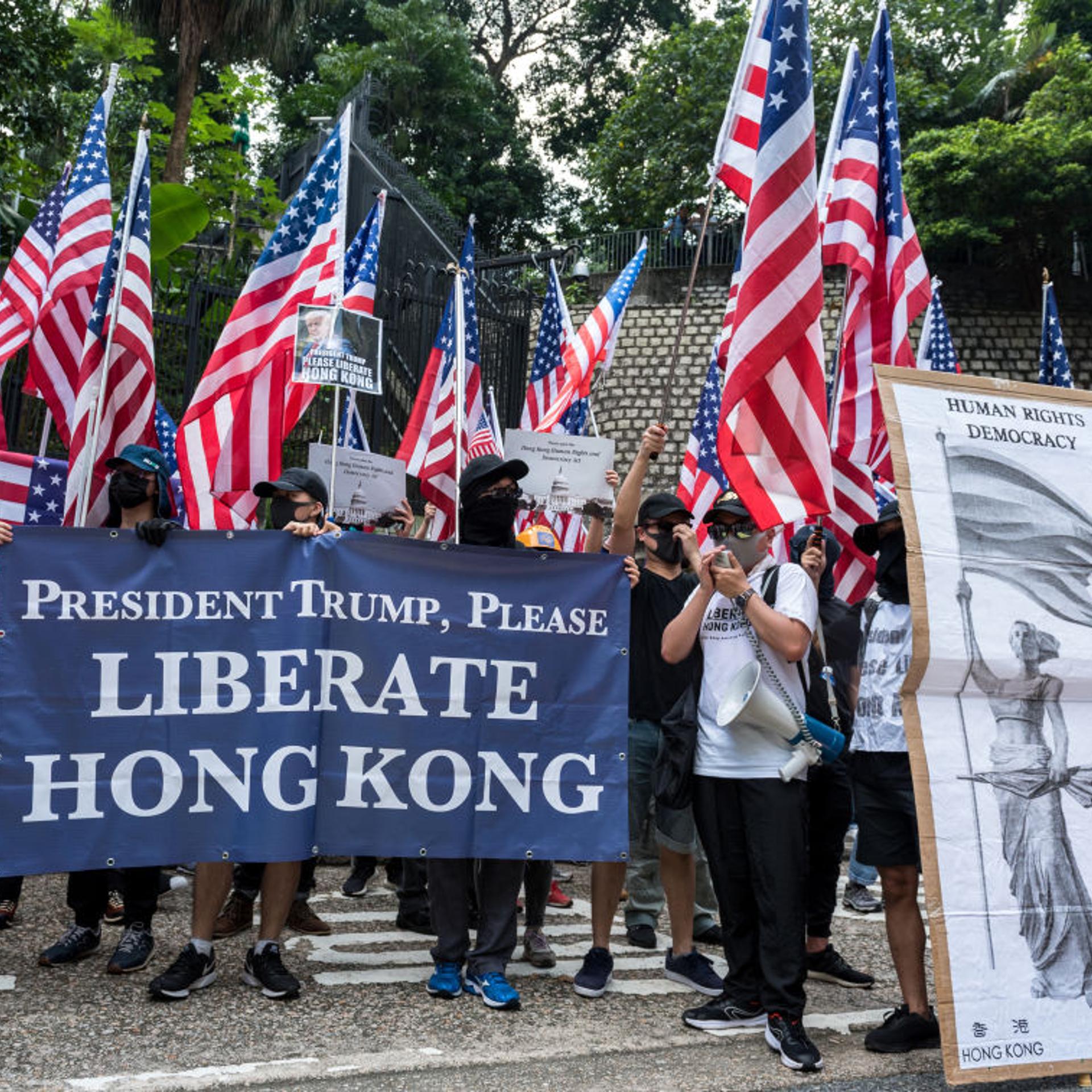 Protesters wave American flags while carrying placards