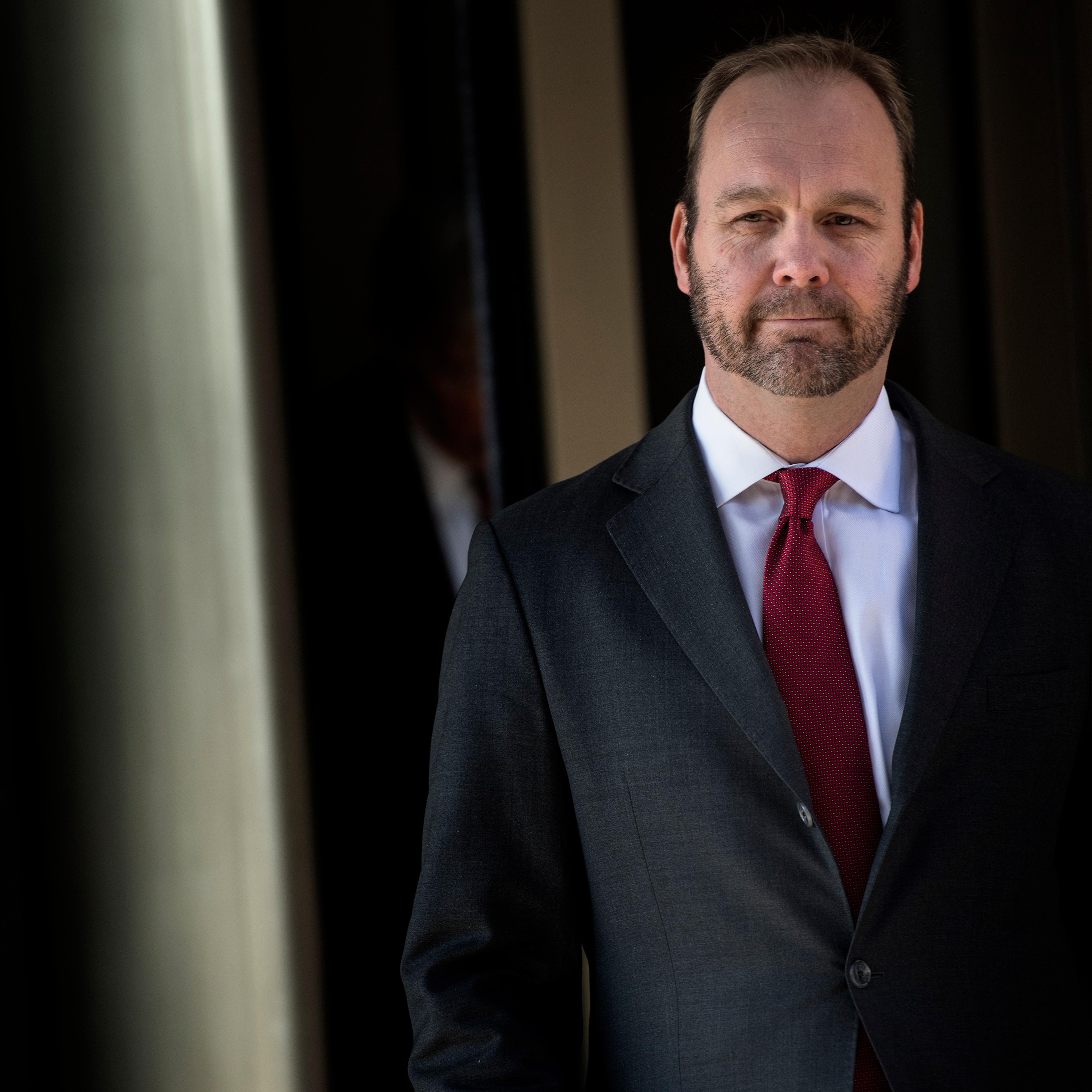 Rick Gates wears a suit and red tie