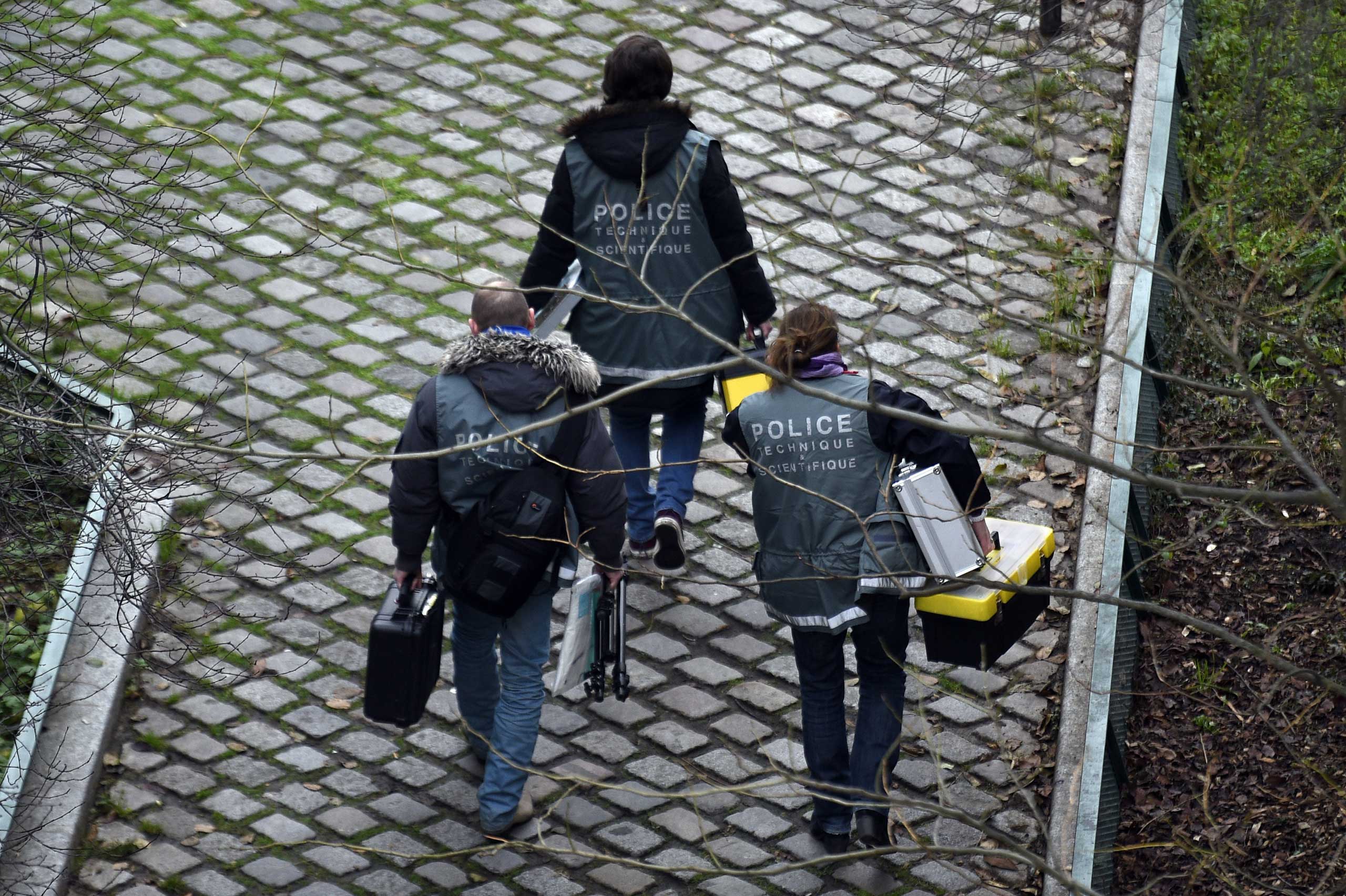 Police investigators seen outside of the headquarters of the French satirical newspaper Charlie Hebdo in Paris after armed gunmen stormed the offices, Jan. 7, 2015.