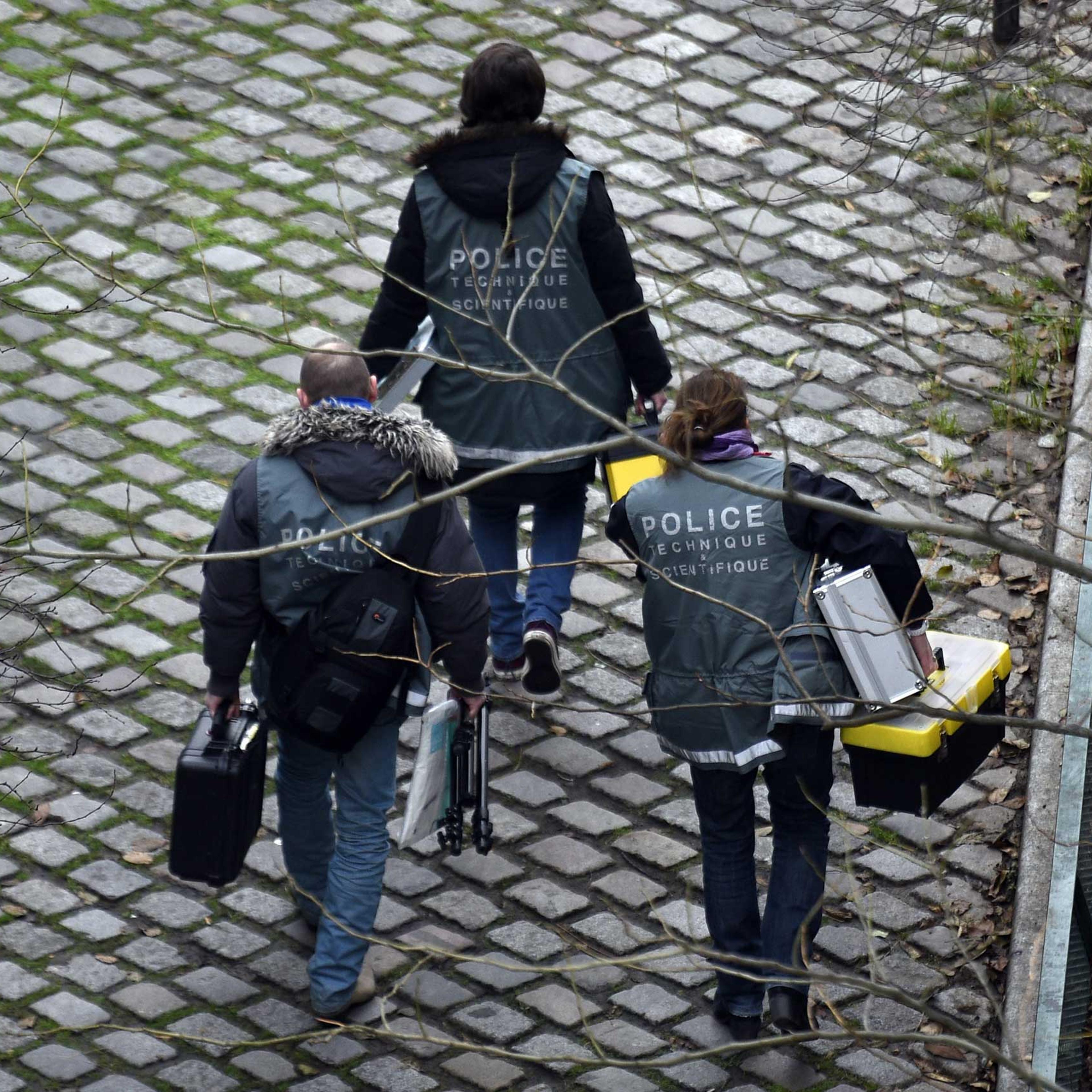 Police investigators seen outside of the headquarters of the French satirical newspaper Charlie Hebdo in Paris after armed gunmen stormed the offices, Jan. 7, 2015.