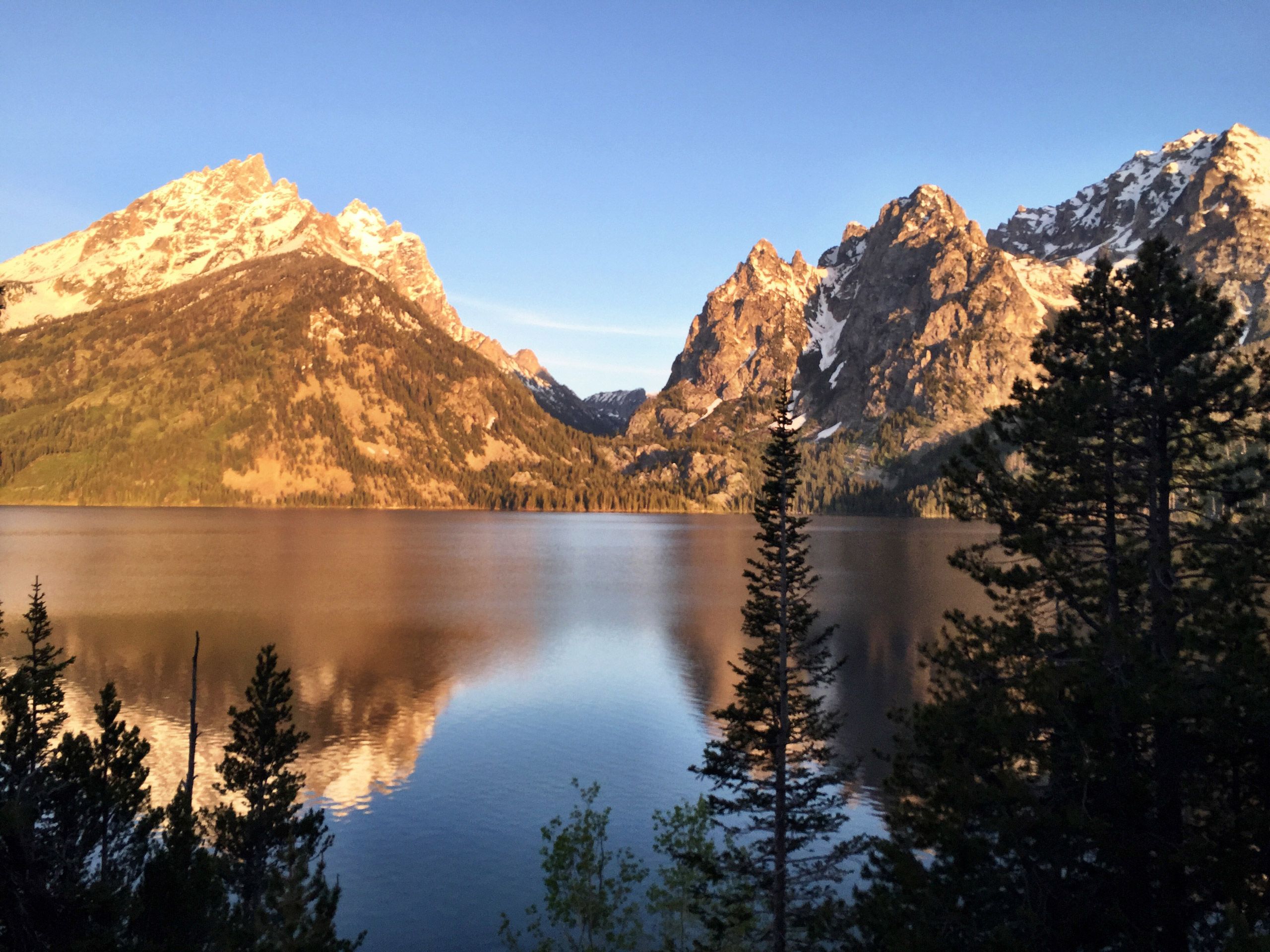 Alpenglow shining on the Grand Tetons is reflected in Jenny Lake June 4, 2015, in Grand Teton National Park, Wyoming. The park offers amazing scenery and hiking opportunities without the crowds of nearby Yellowstone National Park. (Erin Madison/Great Fal