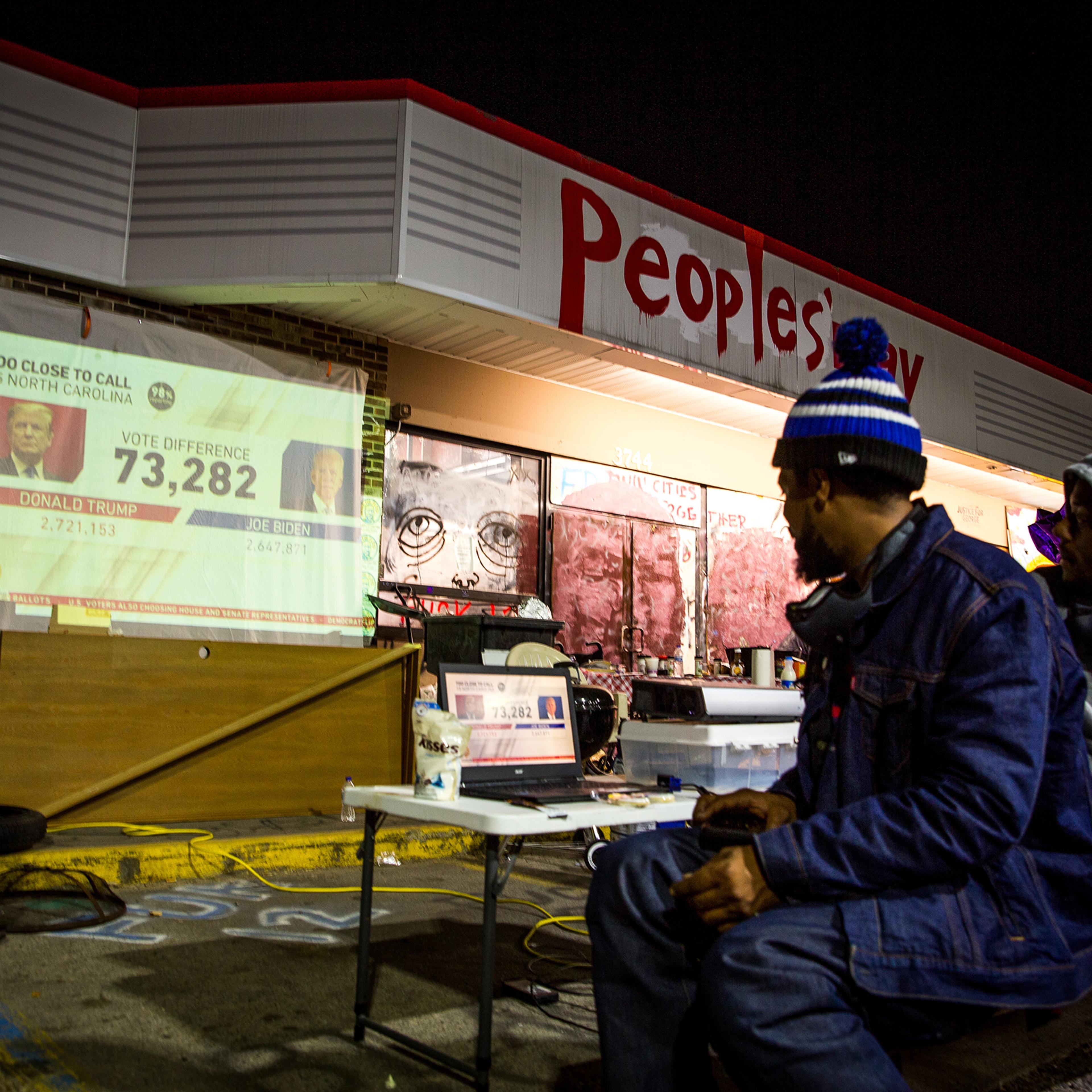 A projector is set up at a George Floyd memorial in Minneapolis for the community to watch election results