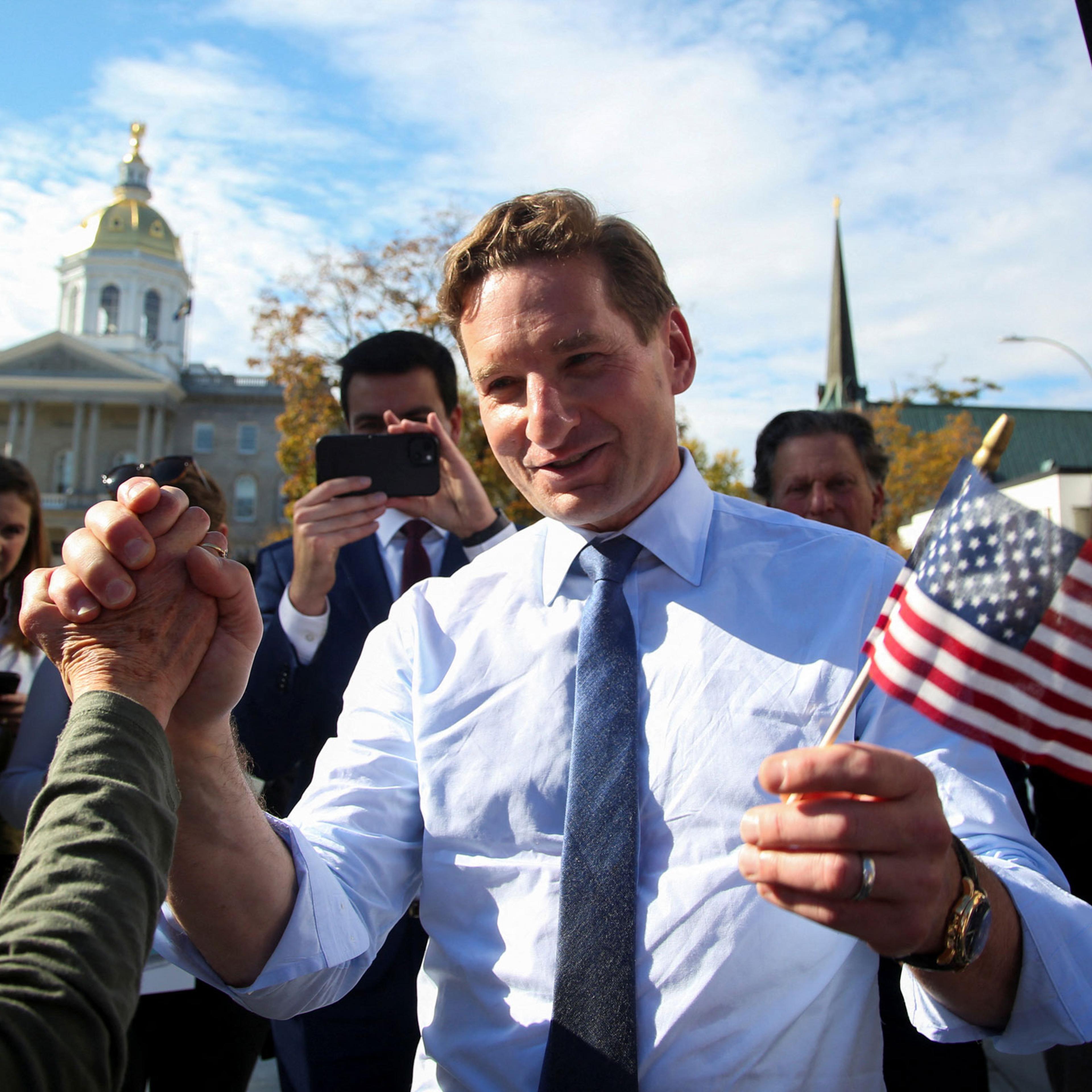 Dean Phillips holds hands with a supporter in New Hampshire