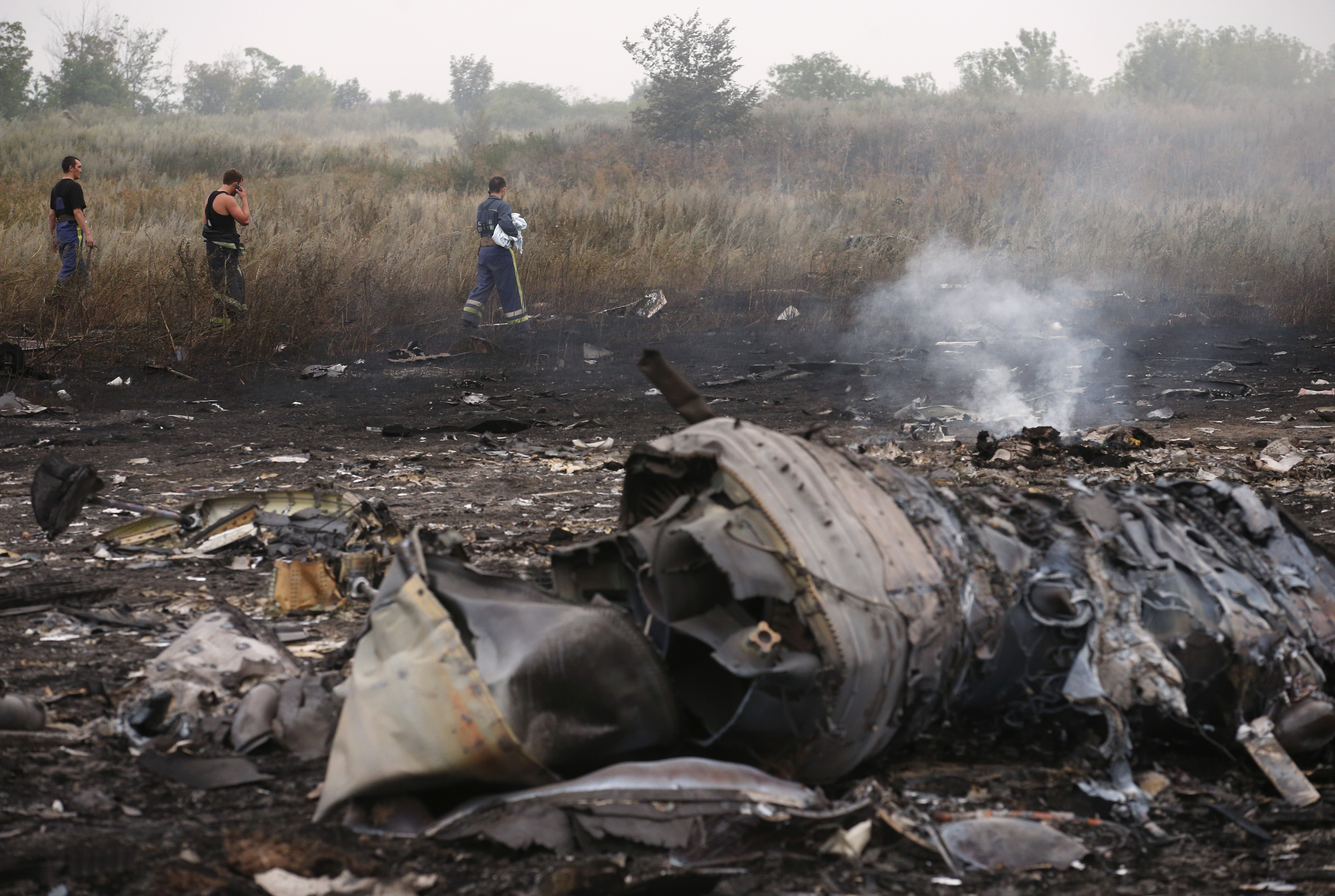 Emergencies Ministry members walk at the site of a Malaysia Airlines Boeing 777 plane crash, MH17, near the settlement of Grabovo in the Donetsk region