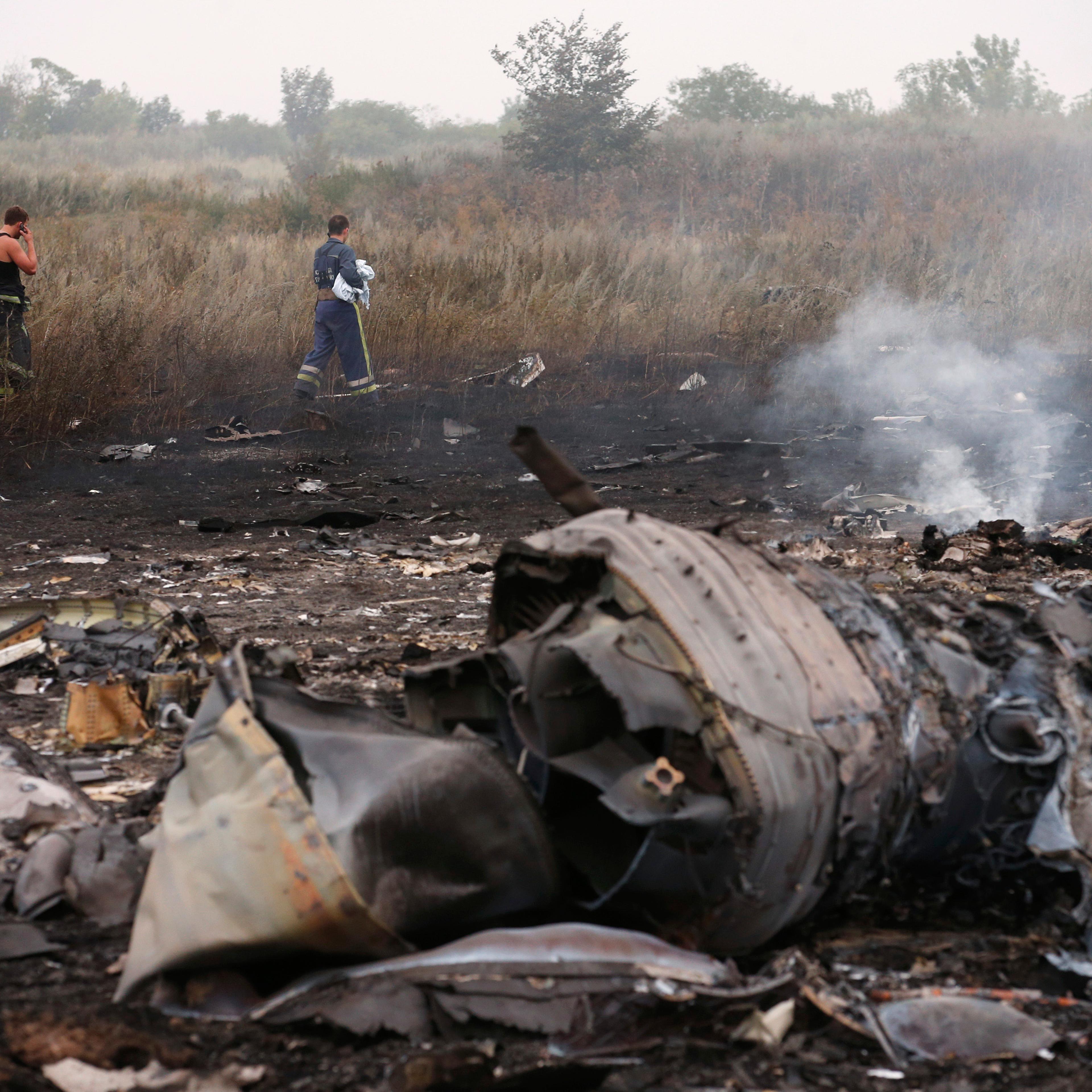 Emergencies Ministry members walk at the site of a Malaysia Airlines Boeing 777 plane crash, MH17, near the settlement of Grabovo in the Donetsk region