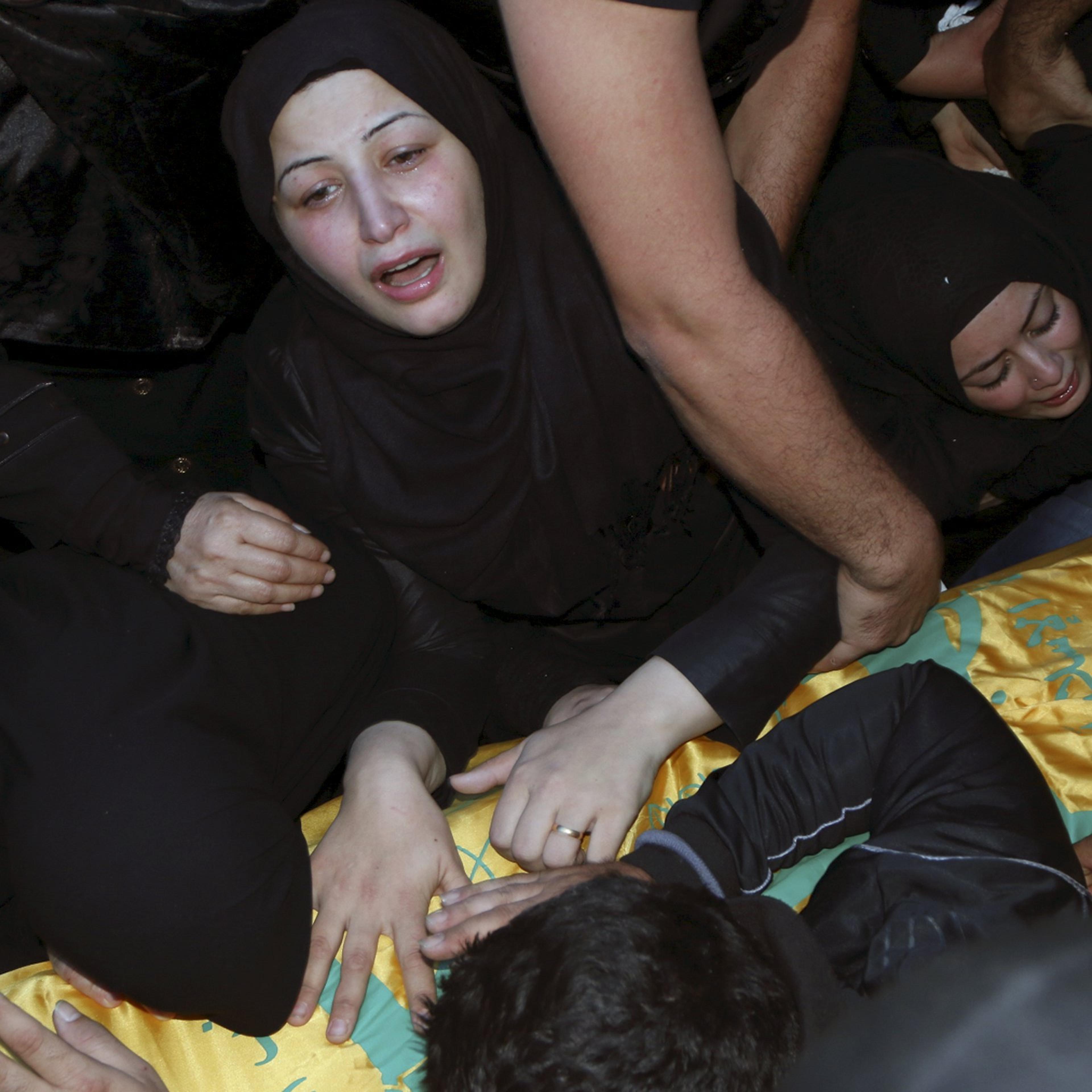 Relatives mourn over the coffin of Hezbollah member, Adel Akram Termos, who was killed in the two explosions that occurred on Thursday in Beirut's southern suburbs, during his funeral in Tallousa village, southern Lebanon on Nov. 13, 2015.