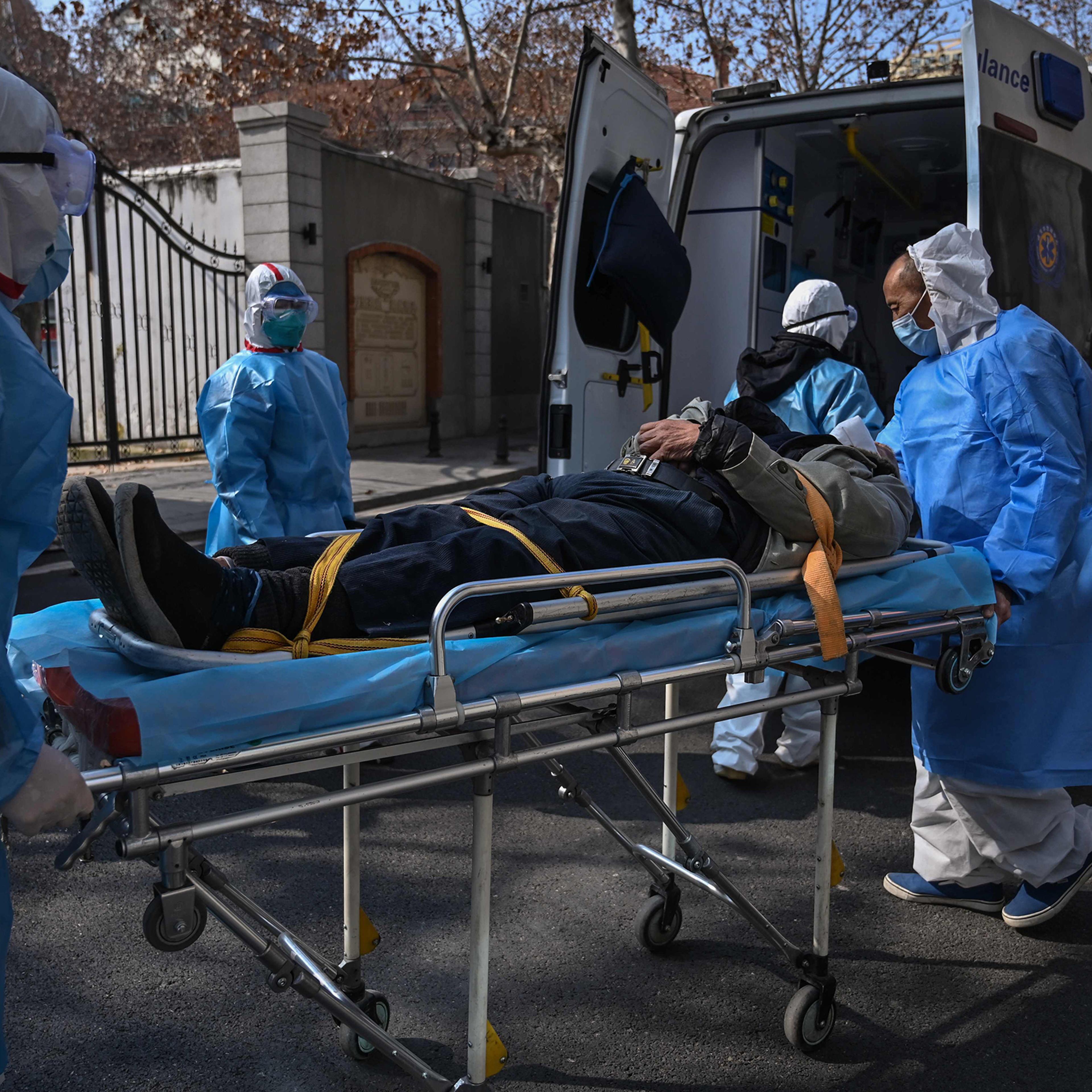 Medical staff in protective clothes carry a suspected coronavirus patient in Wuhan, China, on Jan. 30.