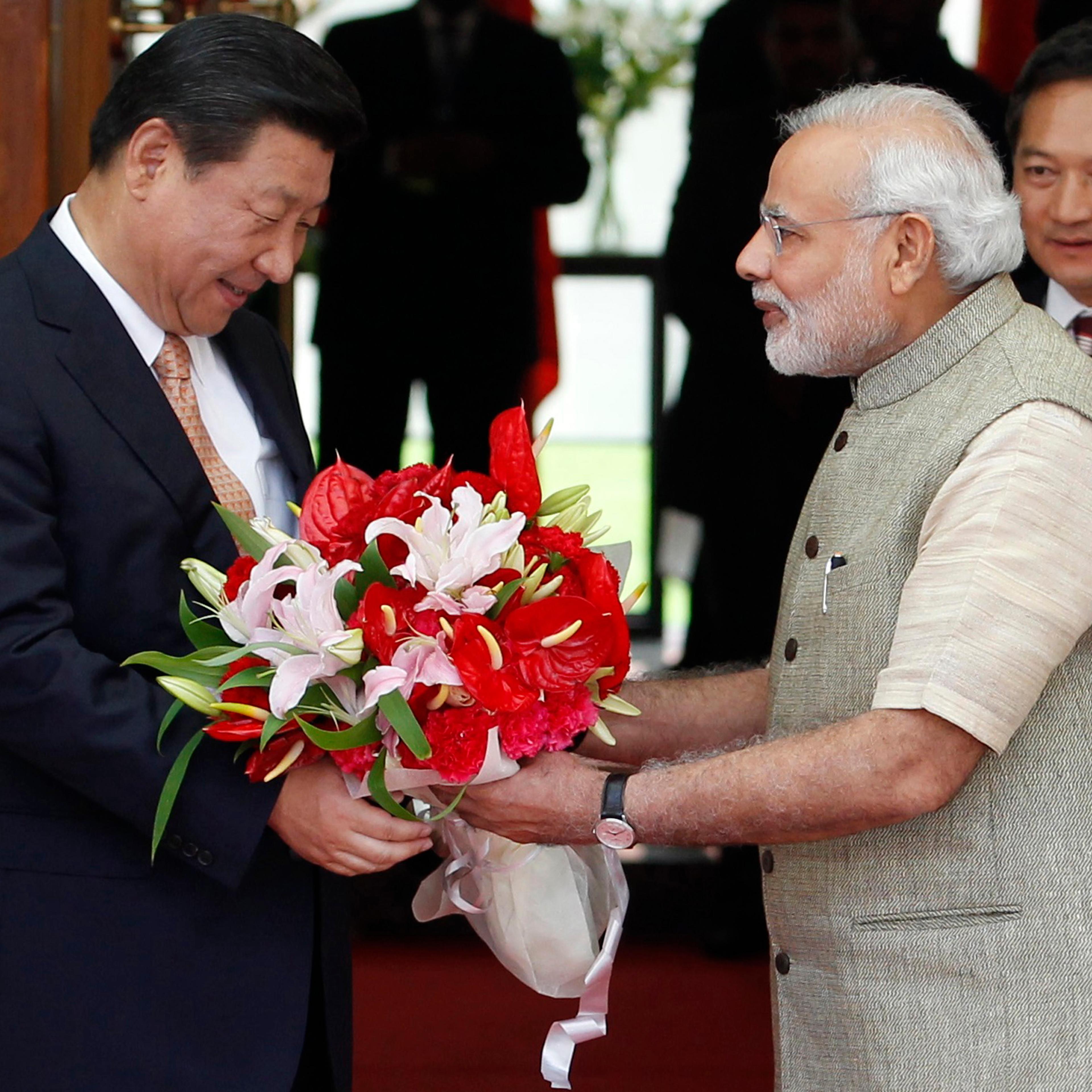 India's PM Modi presents a bouquet to China's President Xi before their meeting in Ahmedabad