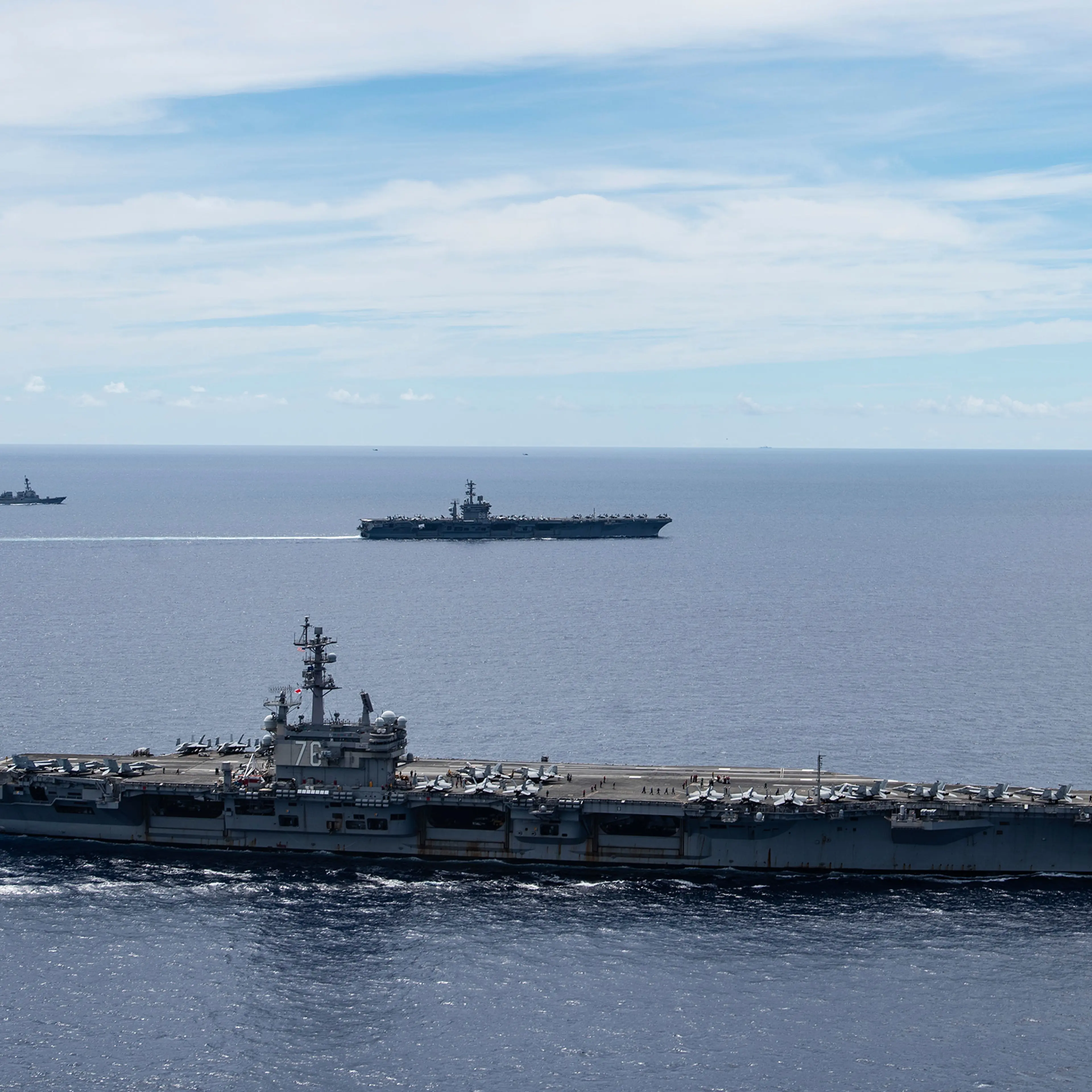 In this July 6, 2020, photo provided by the U.S. Navy, the USS Ronald Reagan (CVN 76, front) and USS Nimitz (CVN 68, rear) Carrier Strike Groups sail together in formation, in the South China Sea