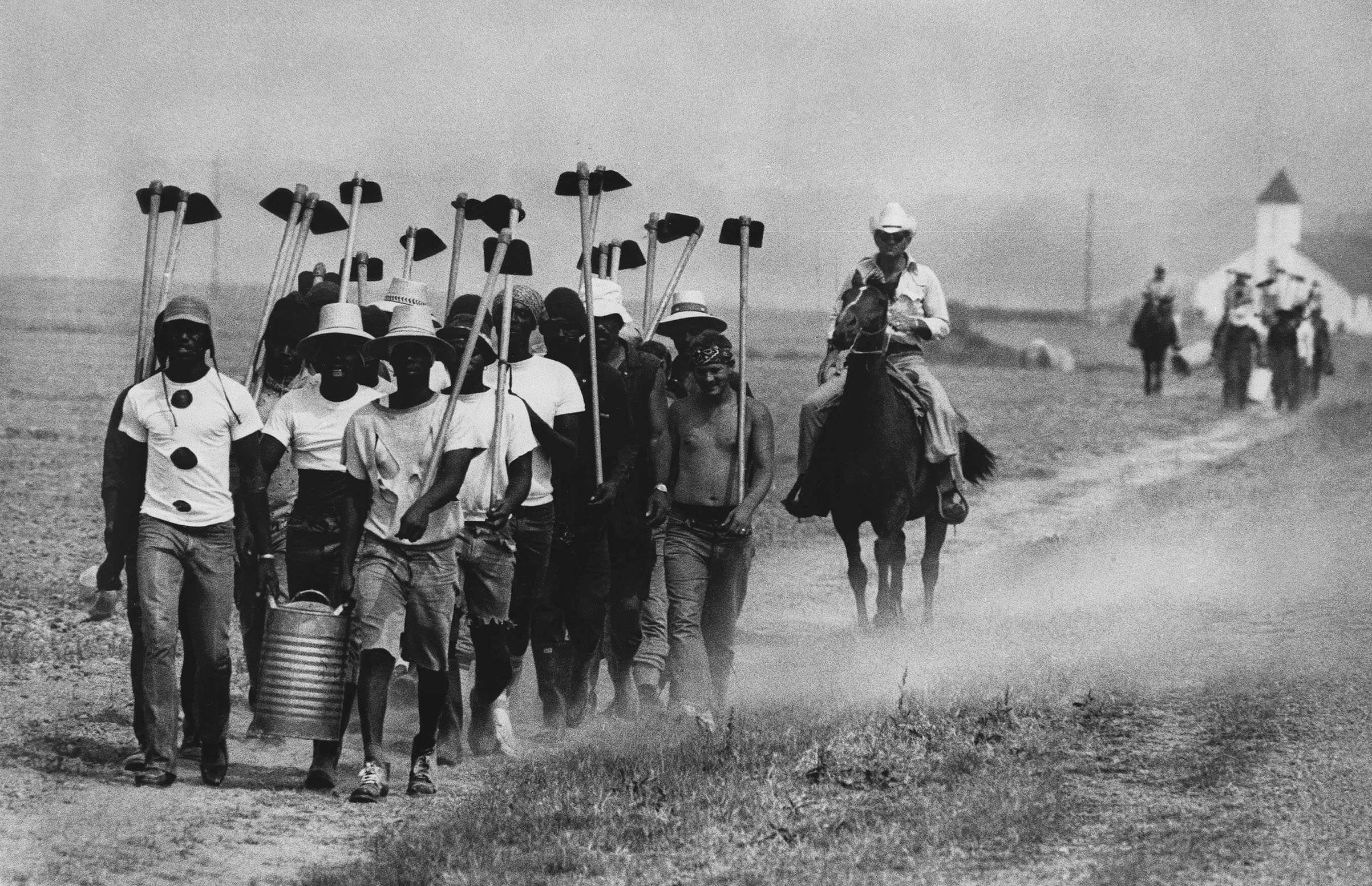 Inmates at Louisiana State Prison in Angola, La., march down a dusty trail on May 30, 1977, en route to working in the fields.