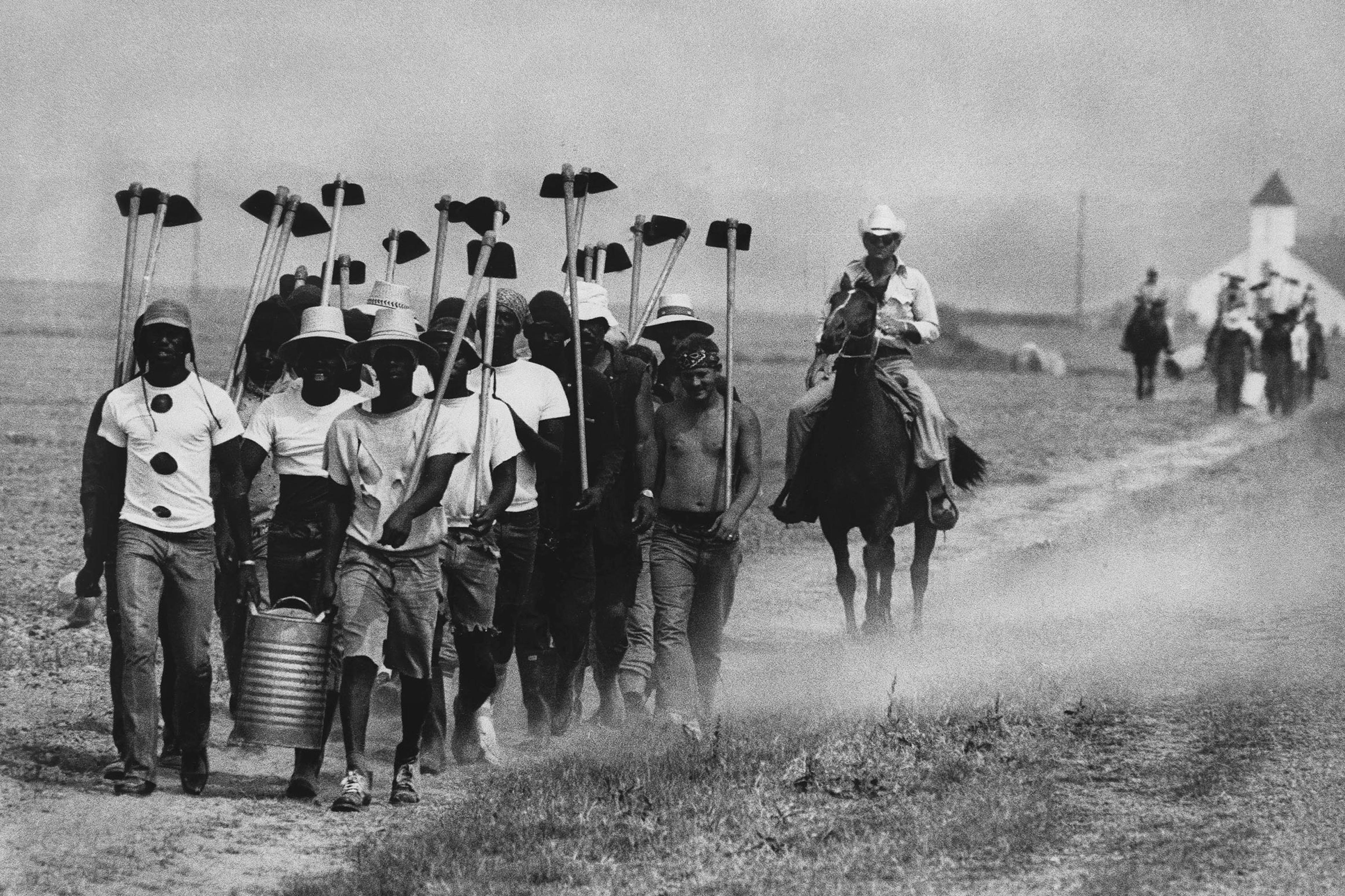 Inmates at Louisiana State Prison in Angola, La., march down a dusty trail on May 30, 1977, en route to working in the fields.