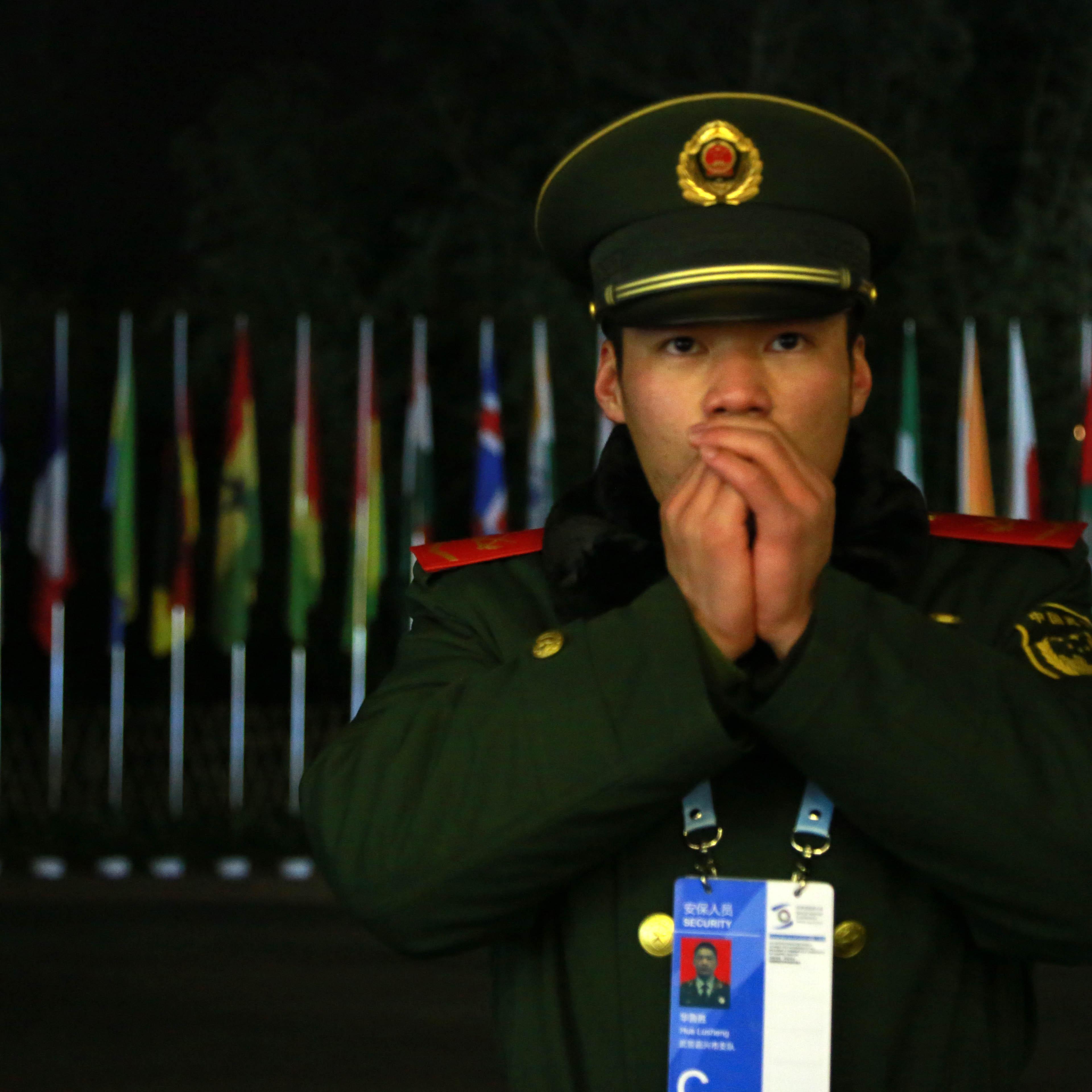 JIAXING, CHINA - DECEMBER 17: (CHINA OUT) An armed police officer exhales to warm himself as he stands guard near the "Light of the Internet" exhibition during the Second World Internet Conference on December 17, 2015 in Jiaxing, Zhejiang Province of Chi